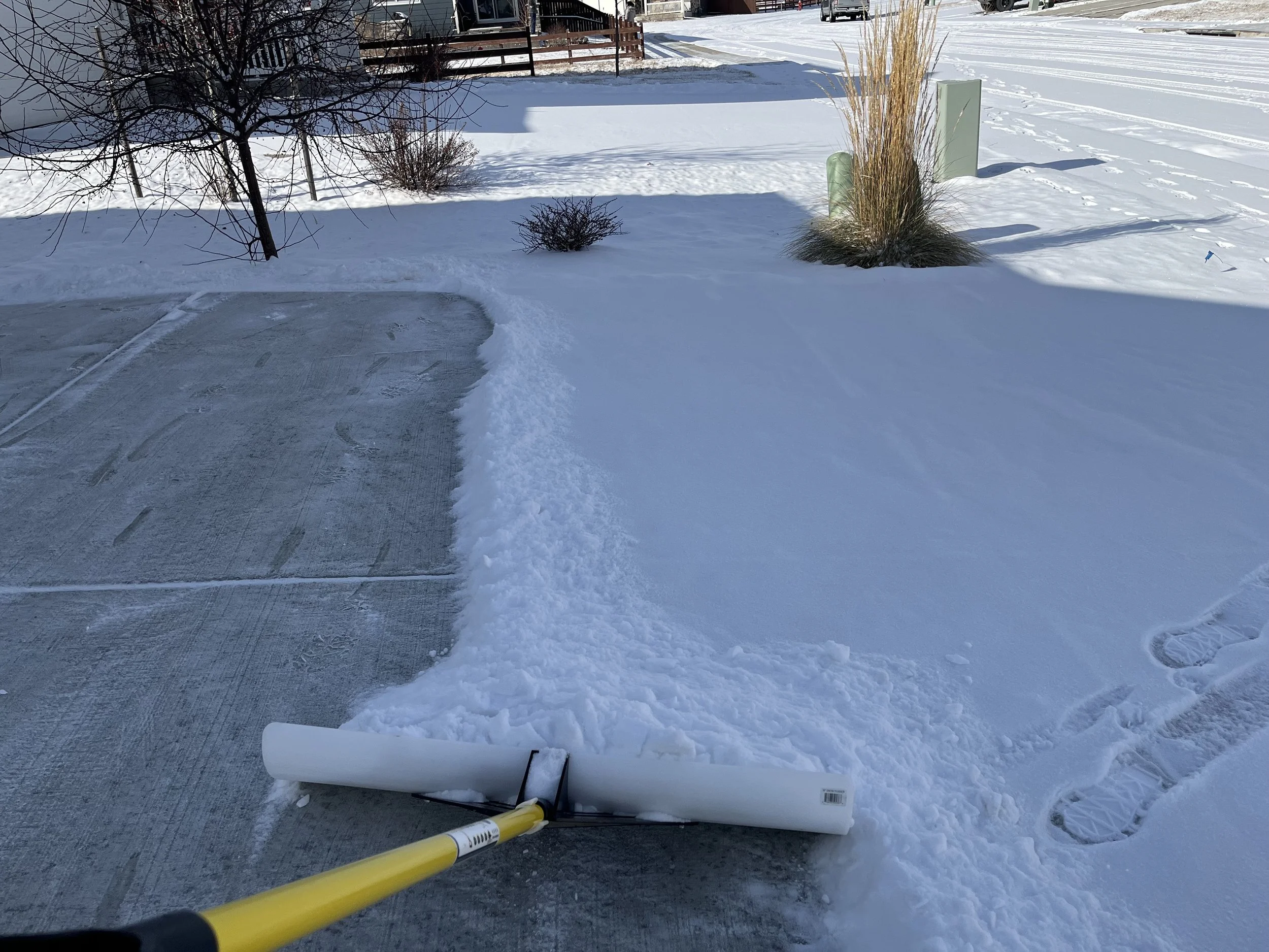 Whipper Snapper Lawn Care clearing snow from a residential driveway with professional snow removal services