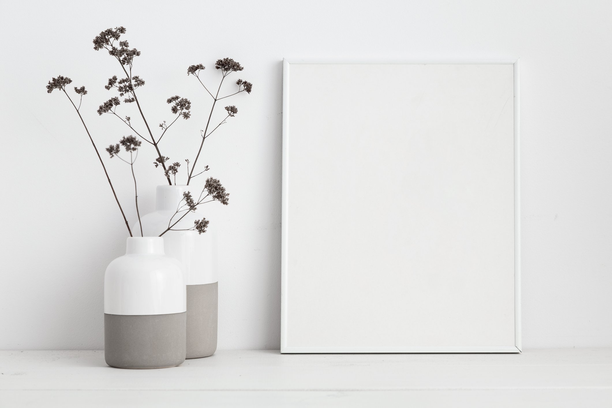Minimalist interior with two vases and blank picture frame
