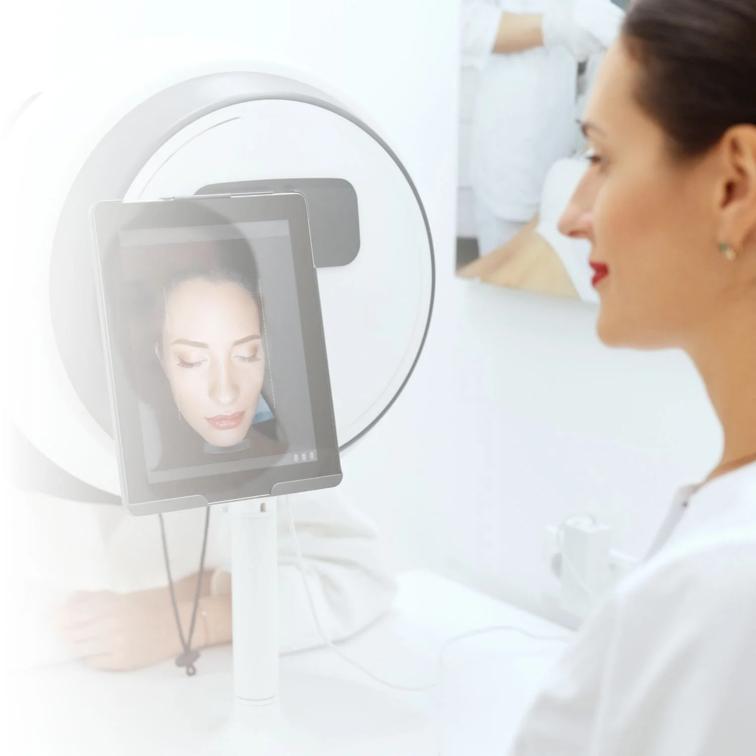 A woman sitting in front of a facial analysis device, viewing her skin on a digital screen.