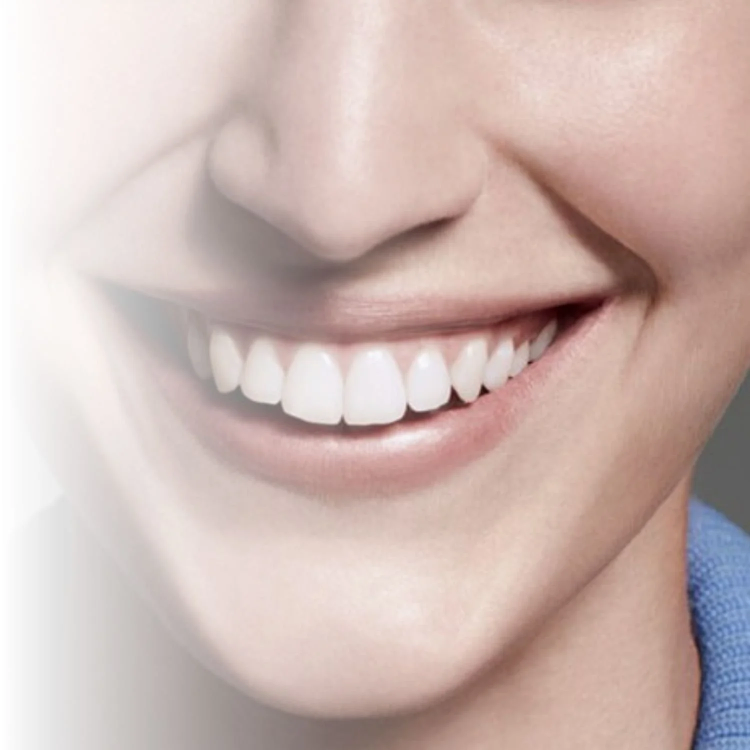 Close-up of a smiling person's mouth showing white teeth.