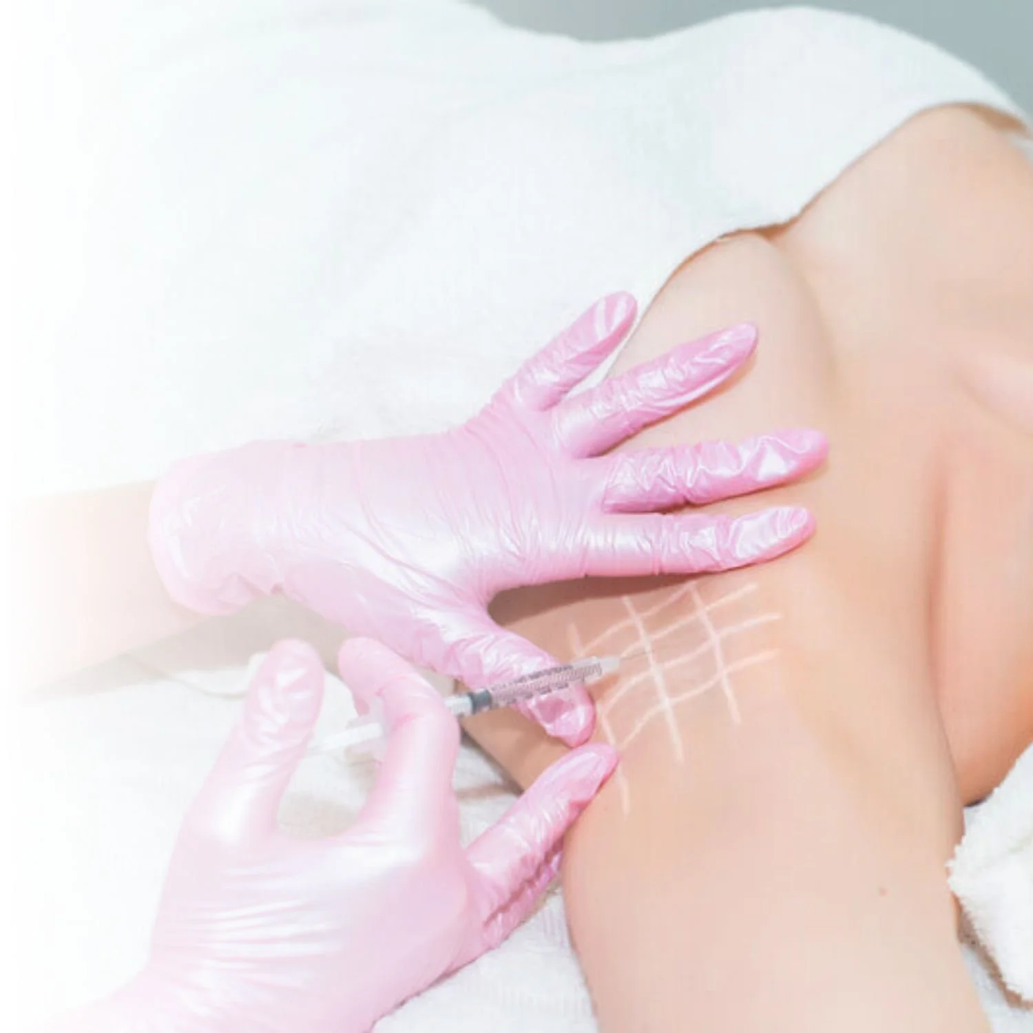 Person receiving cosmetic injection in knee area with pink gloves.