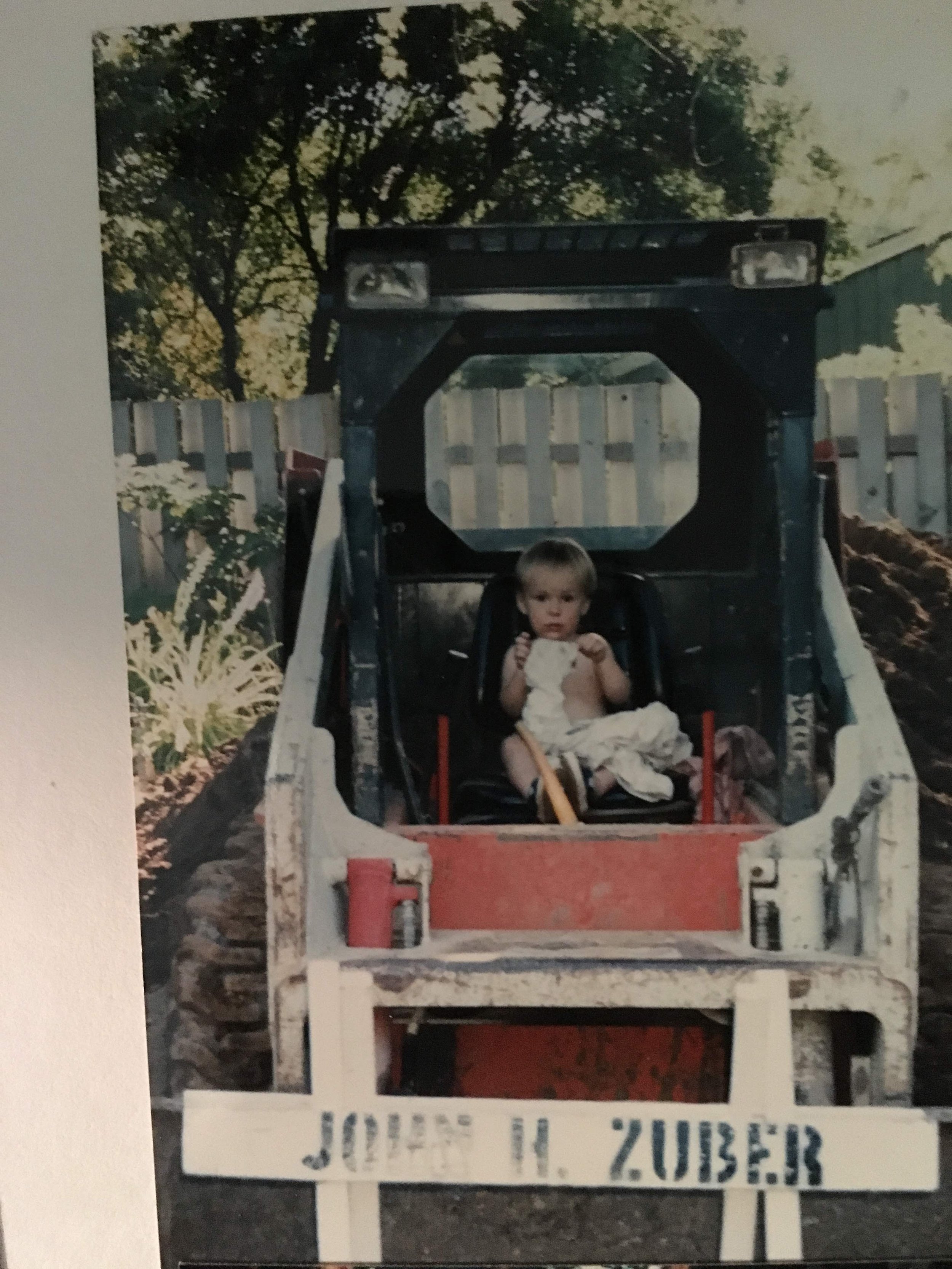 John Livingston Bullier as a child sitting in a skid steer.