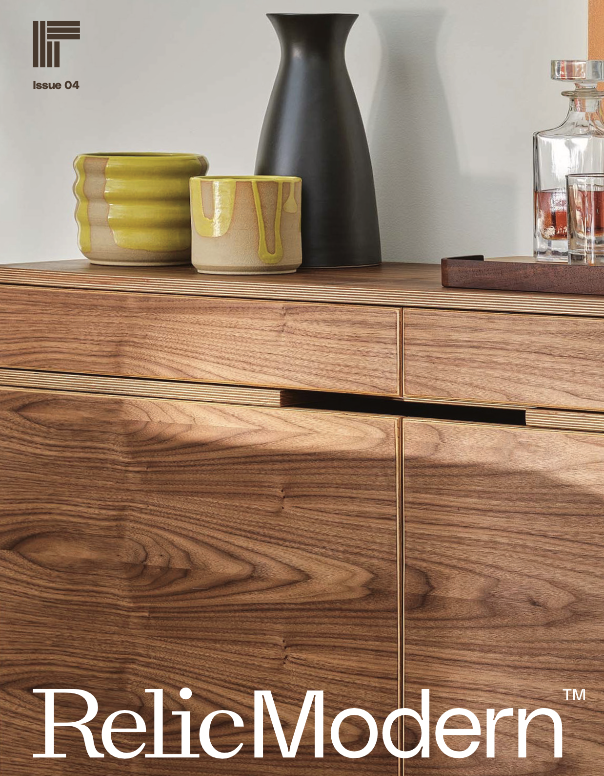 Close-up of a wooden sideboard with decorative vases, bowls, and a tray on top.