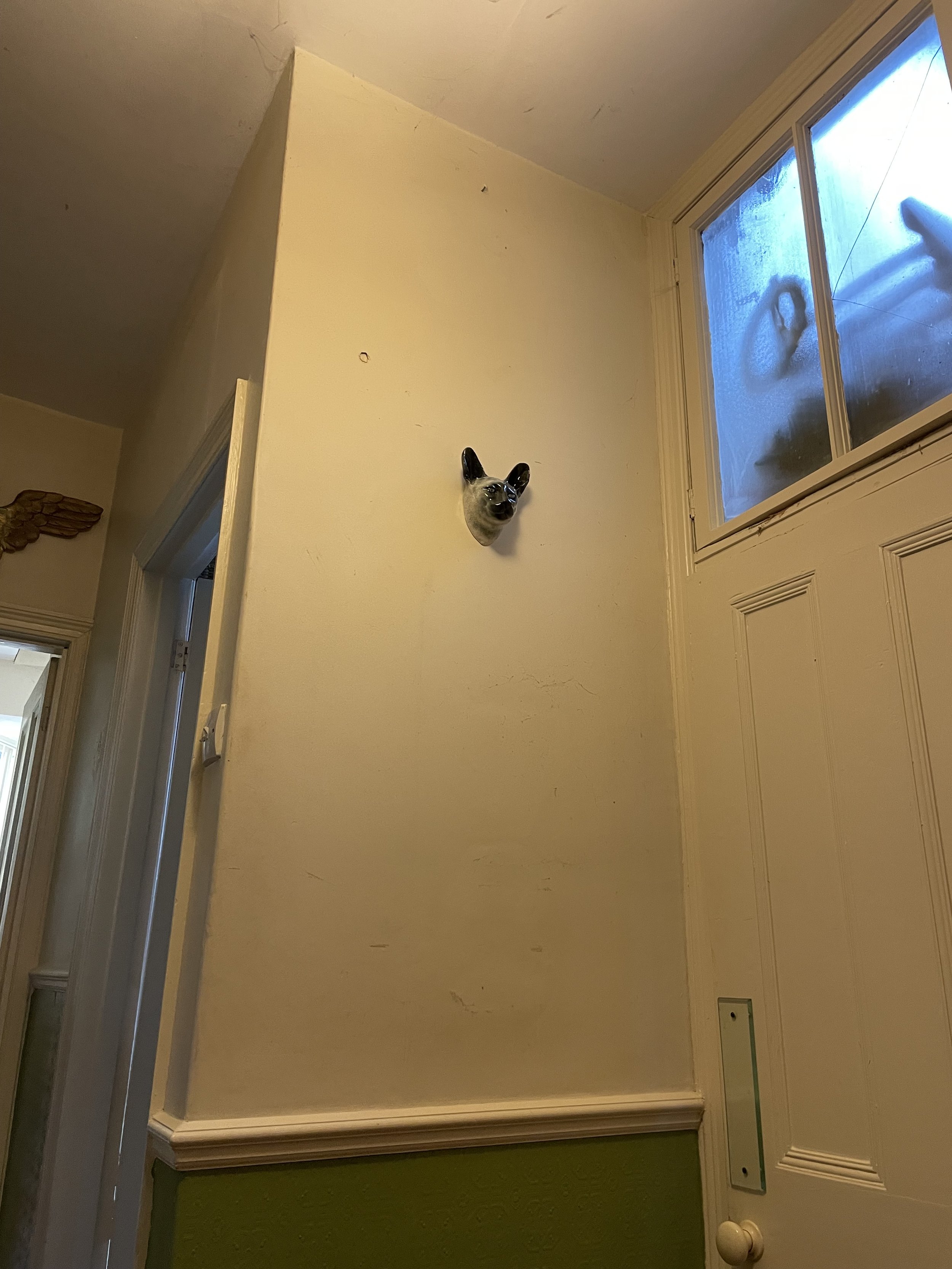 Detail of handmade slip-cast ceramic Siamese cat wall sculpture