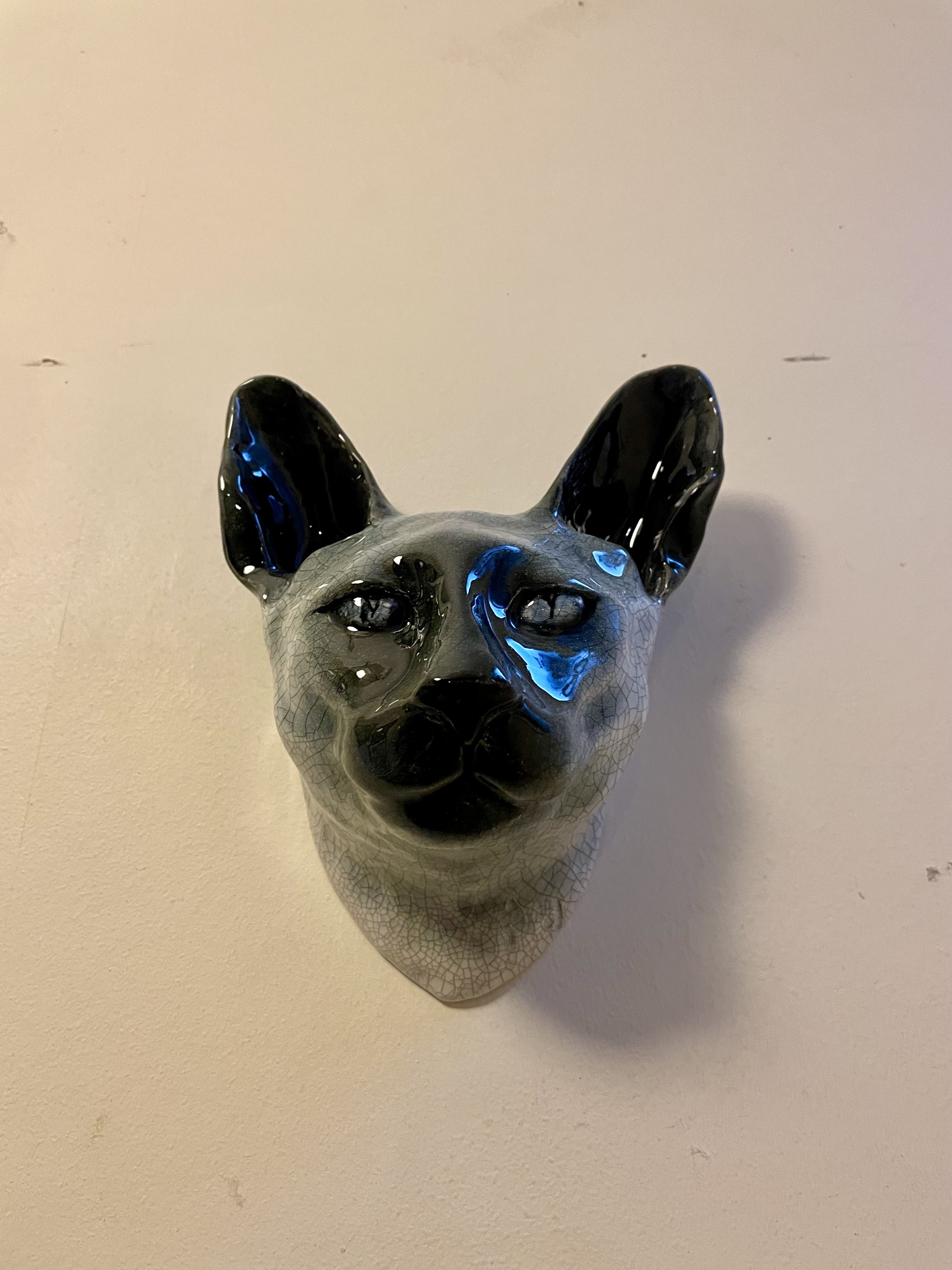 Detail of handmade slip-cast ceramic Siamese cat wall sculpture