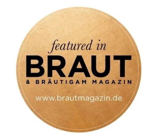 Ein runder Aufkleber mit einem braunen Hintergrund, der den Text 'featured in BRAUT & BRÄUTIGAM MAGAZIN www.brautmagazin.de' enthält.