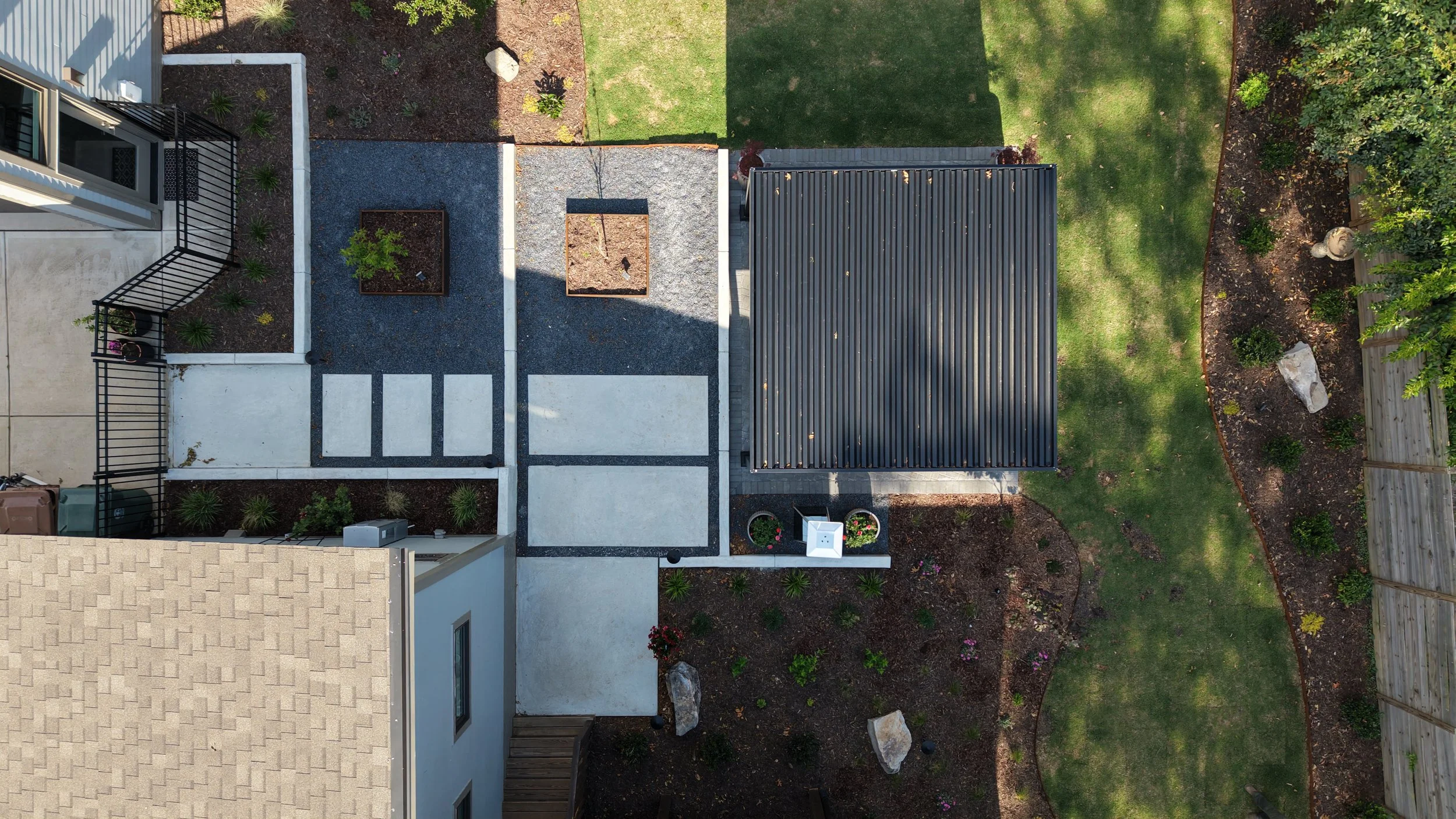 Combination of concrete patio slabs and paver patio with pergola and landscape in Cary, NC