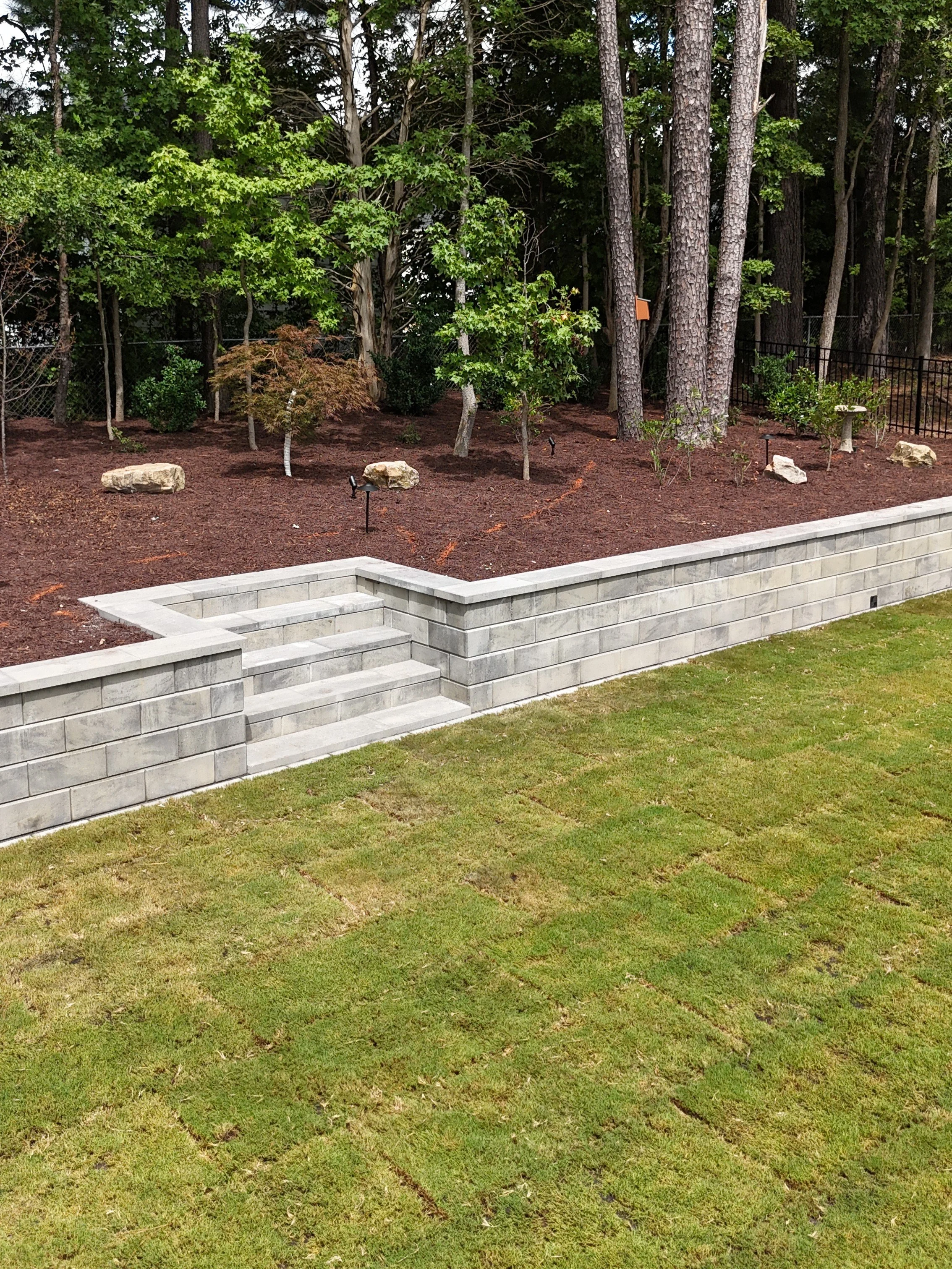 Modern retaining wall with sod and landscaping elements in Apex, NC