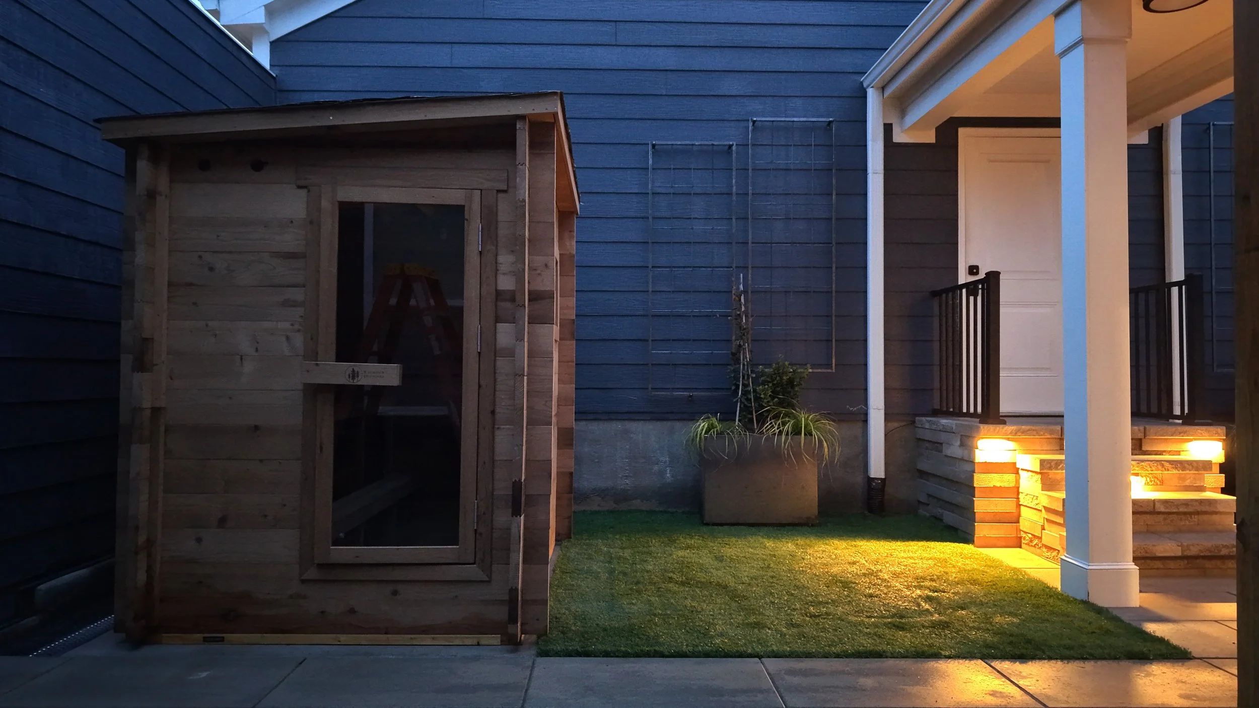 Outdoor living space with hardscaping, sauna, and artificial turf in Cary, NC