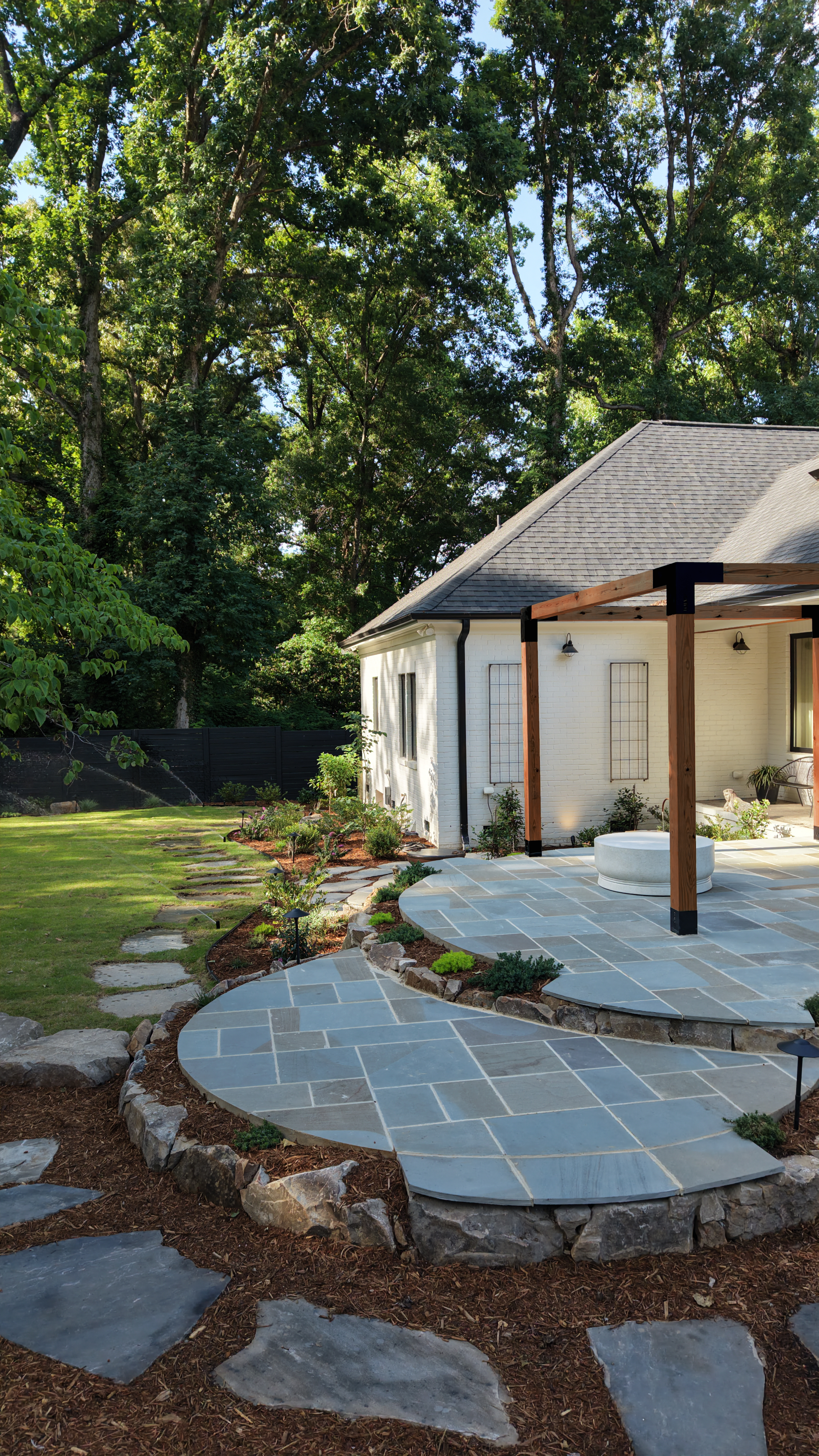 Bluestone patio with pergola and landscape elements in Cary, NC
