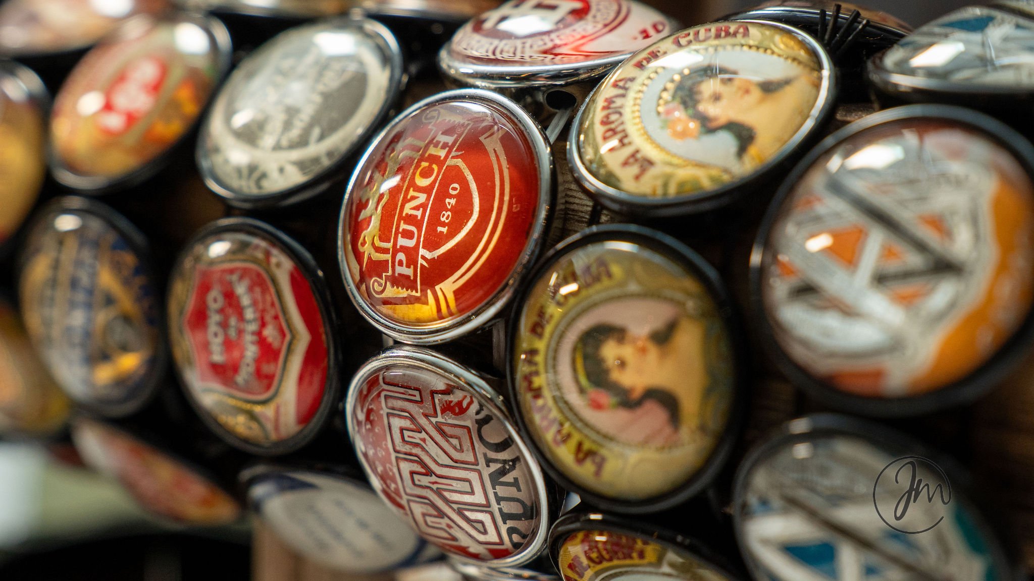 Close-up of various vintage cigar and vape lid tins arranged together.