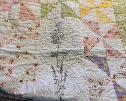 Detail of the hand embroidered panel and the custom quilting around it