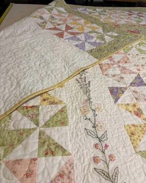 Here are the details of the back top that were added.  The client requested that I add about a 16" band of pinwheels and border along the top that could be revealed when it was turned back at the head of the bed.  The quilt was also now bound in a be