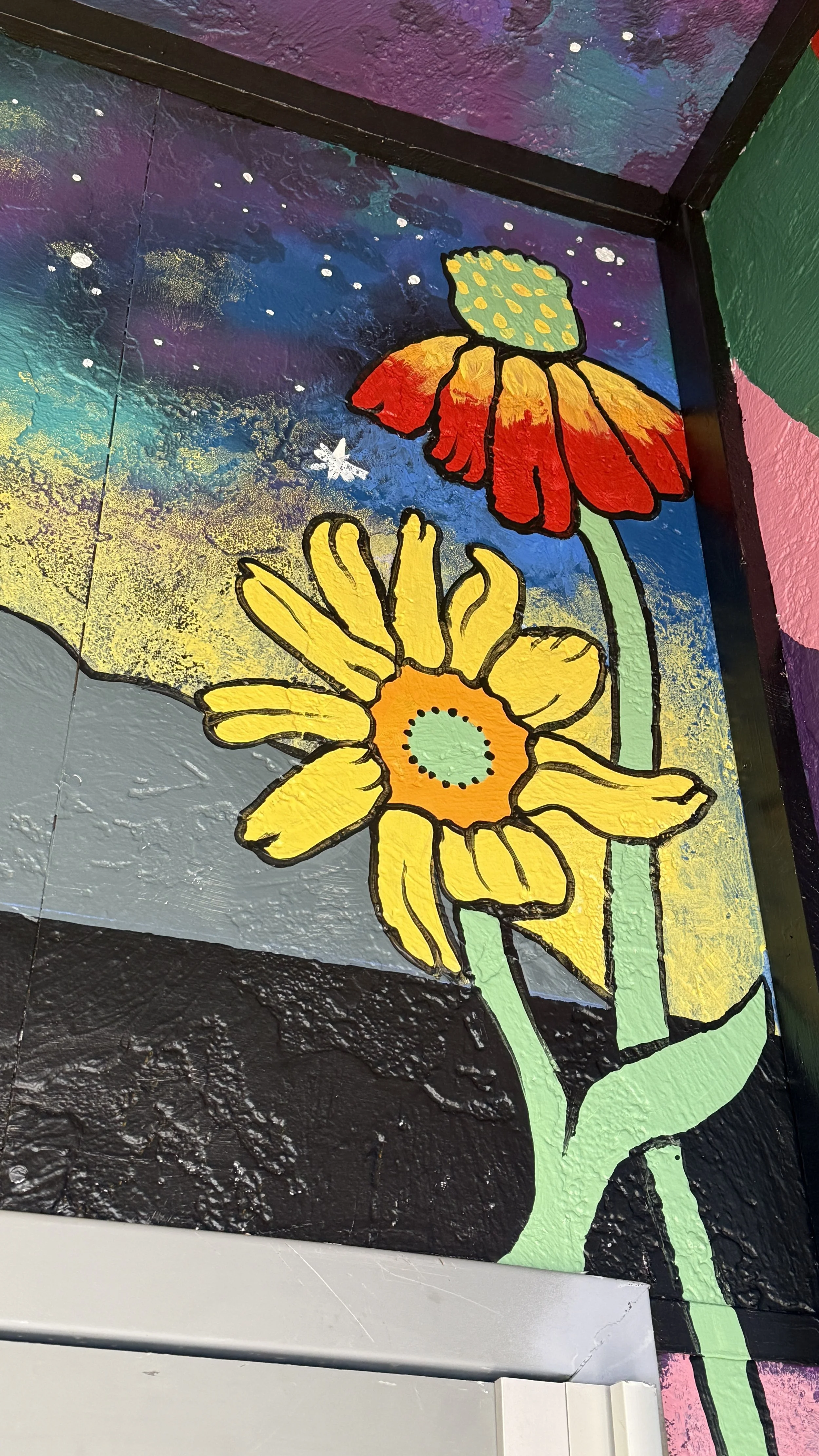 A detailed close up of two flowers at the Beaver Street Theatre entryway mural.