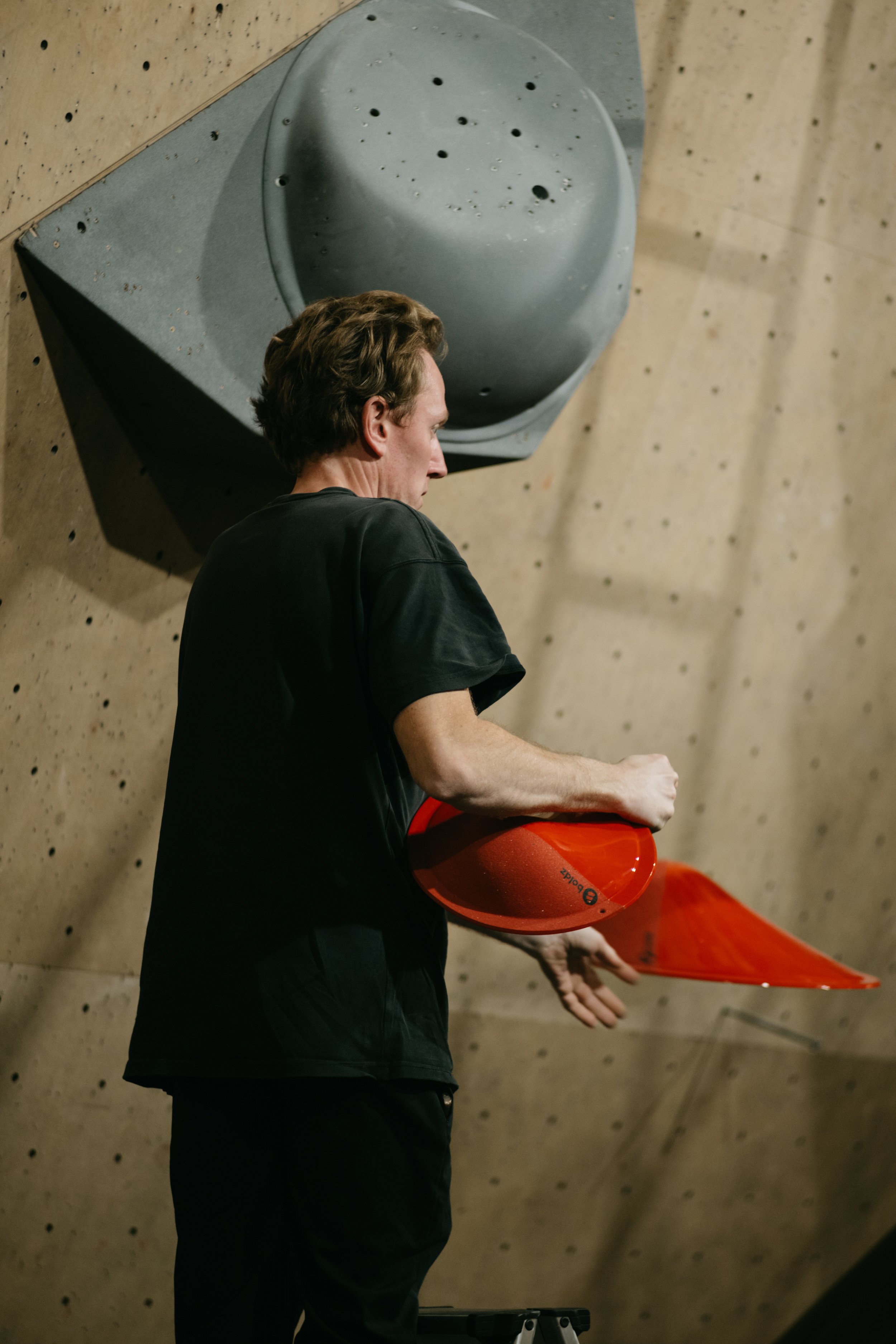 Route setter preparing the finals for Tba 4 at Climbing District Paris on Boldz Holds Double texture Volumes
