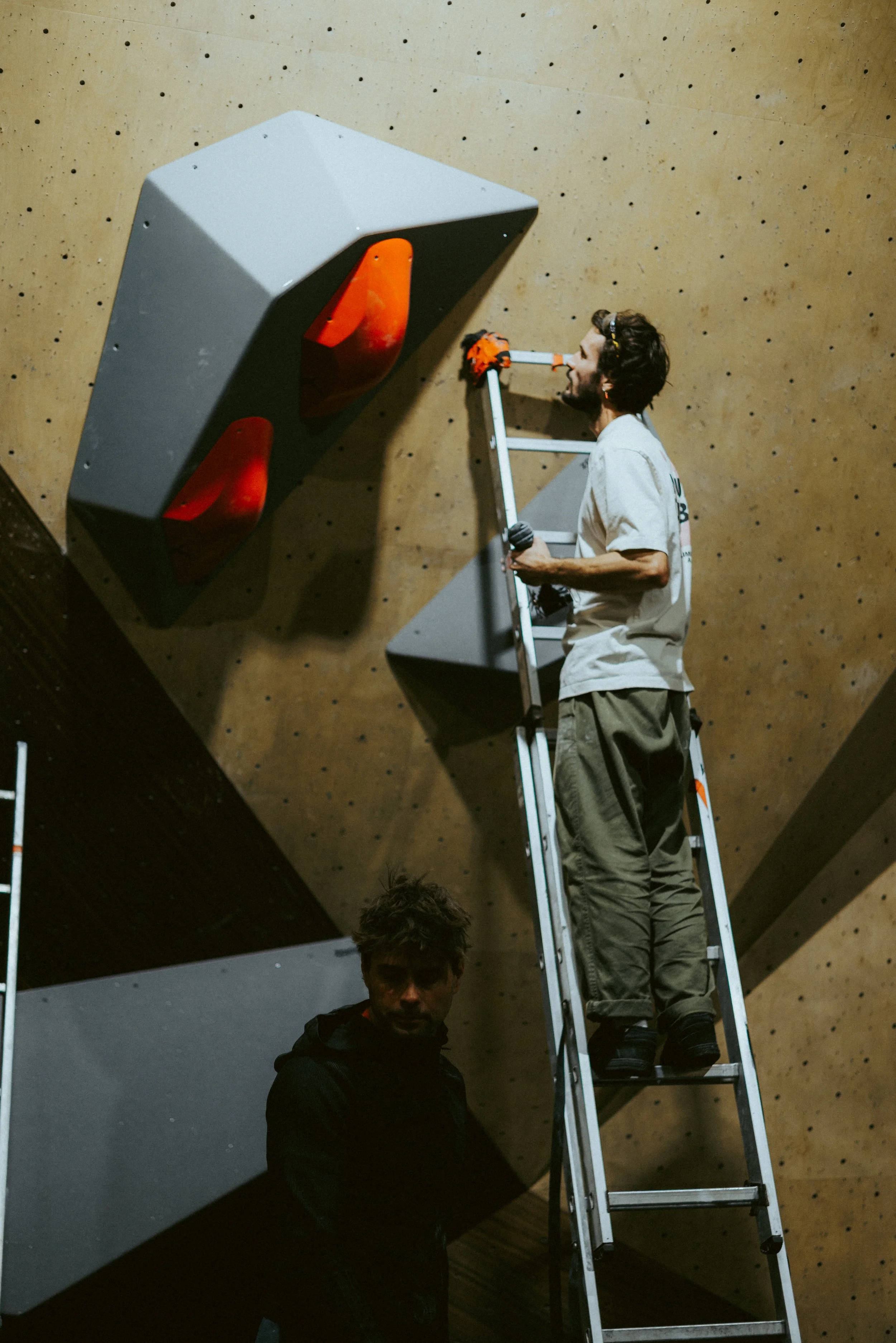Route setter preparing the finals for Tba 4 at Climbing District Paris on Boldz Holds Double texture Volumes 