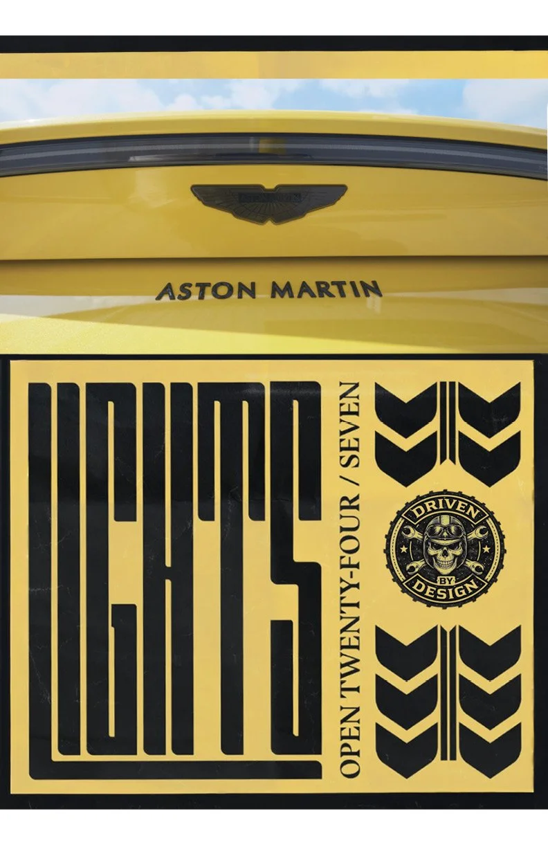 A yellow Aston Martin car with a black emblem and the words 'Aston Martin' written beneath the emblem. Below the car, there is a black and yellow design featuring bold vertical lines and the text 'Open twenty-four / seven'. On the right side, there are three stylized black chevrons, a circular badge with a skull wearing goggles and the words 'Driven by design' around it.