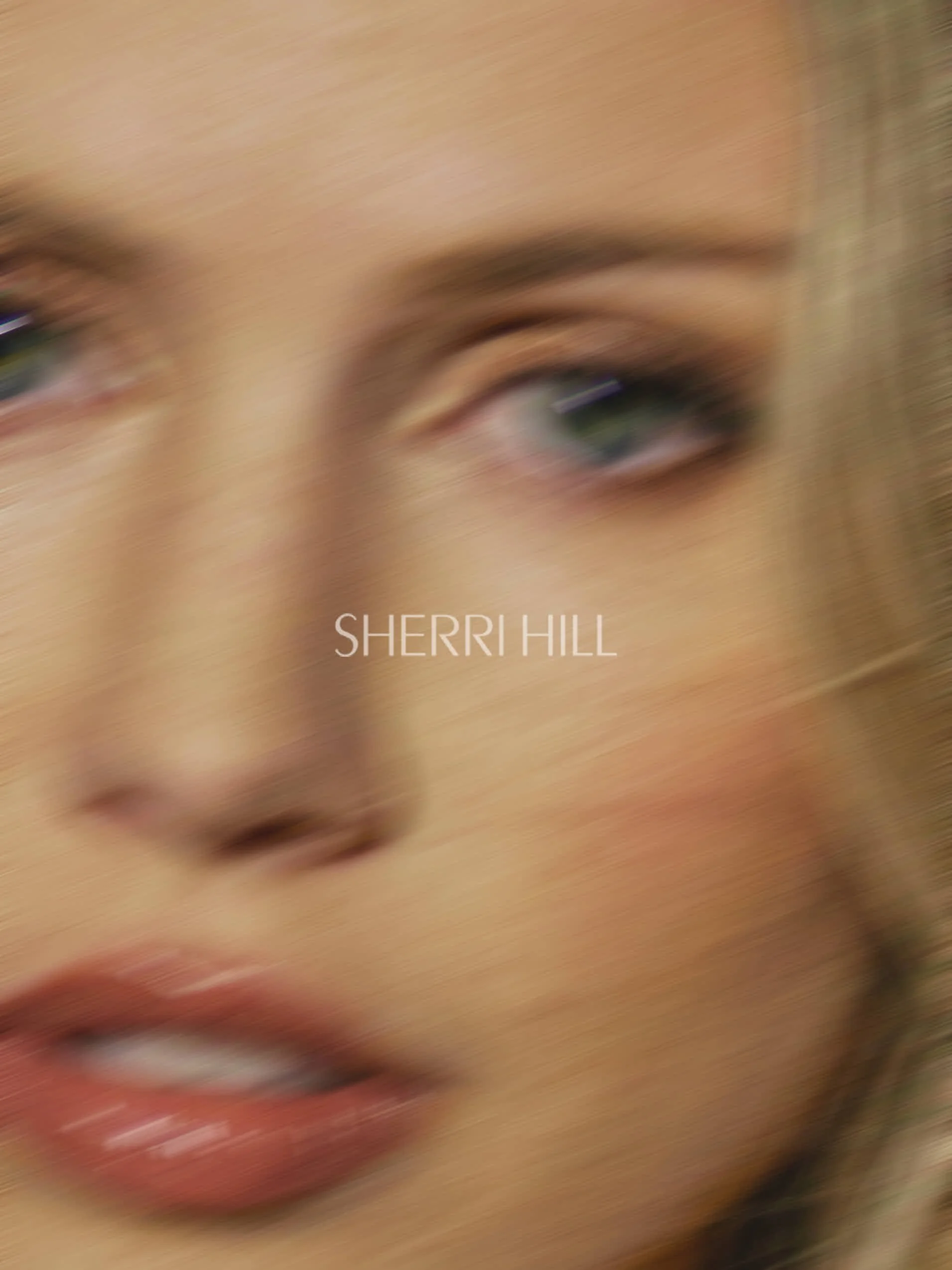 Blurry close-up of a woman's face with the text 'SHERRI HILL' in the center.