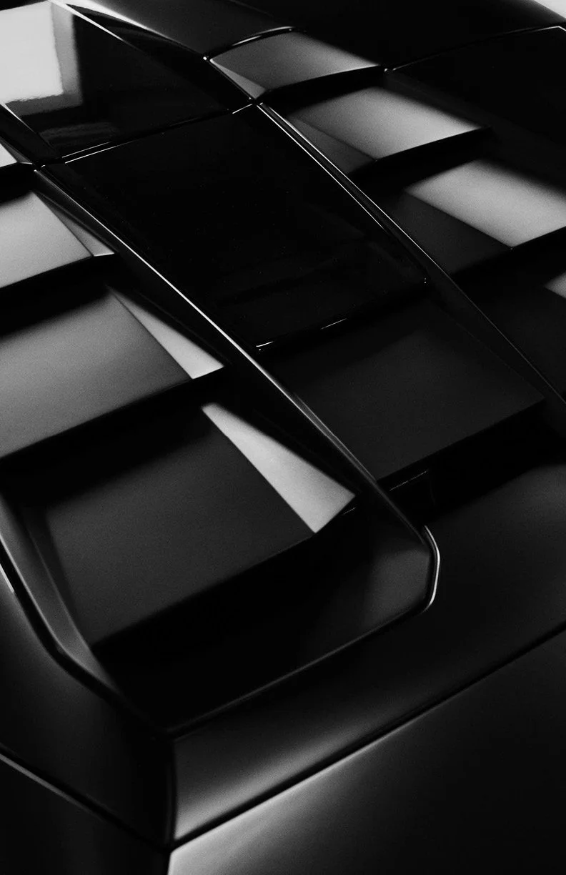 Close-up of a sleek, black, modern car hood with reflective paint and aerodynamic design elements.