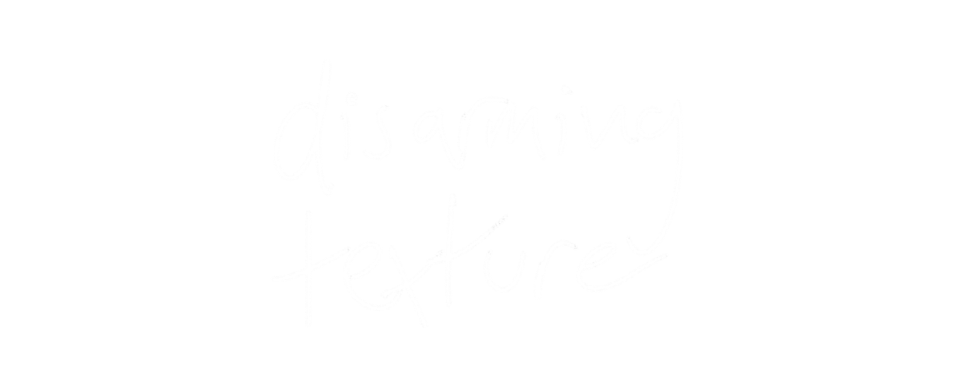 White handwritten text on a black background that reads "disarming texture".