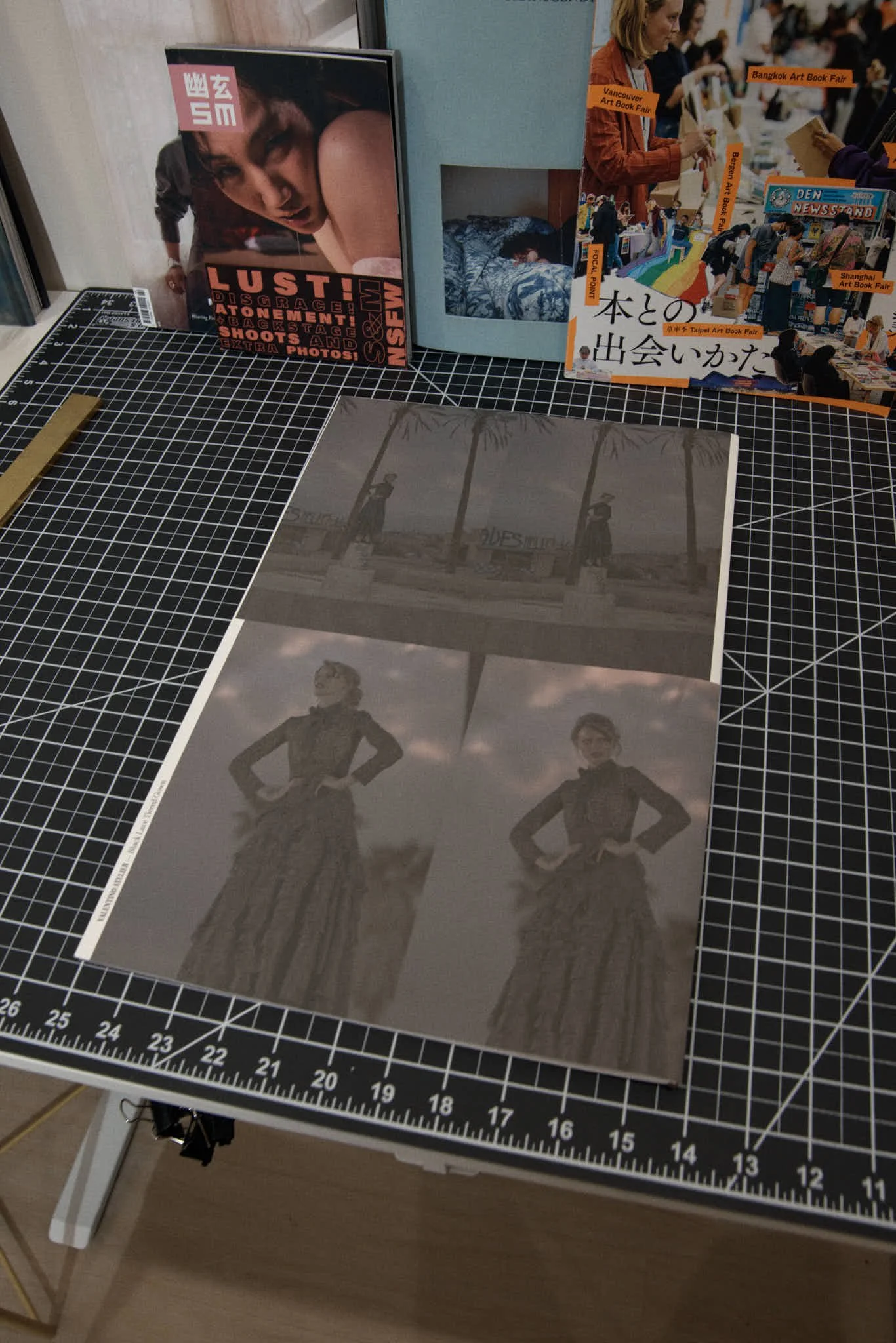 Black and white photographs of a woman in a dress, one in a full-body pose and the other a waist-up portrait, laid out on a cutting mat with a grid.