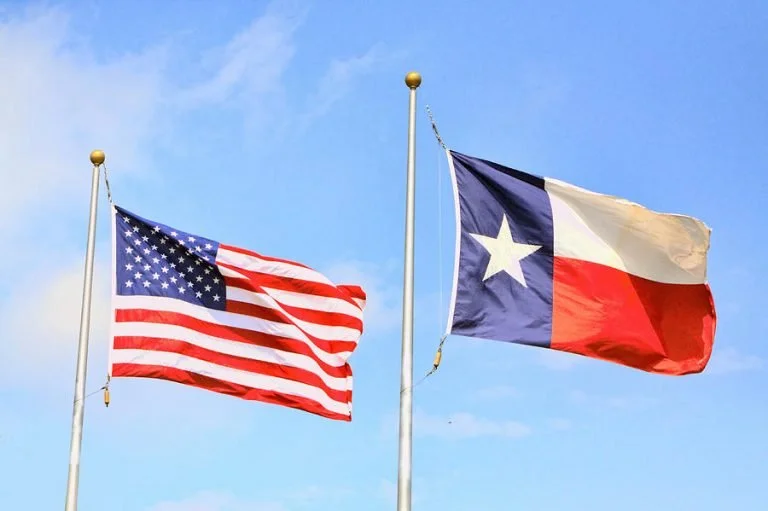The US and Texas flags wave in the breeze.
