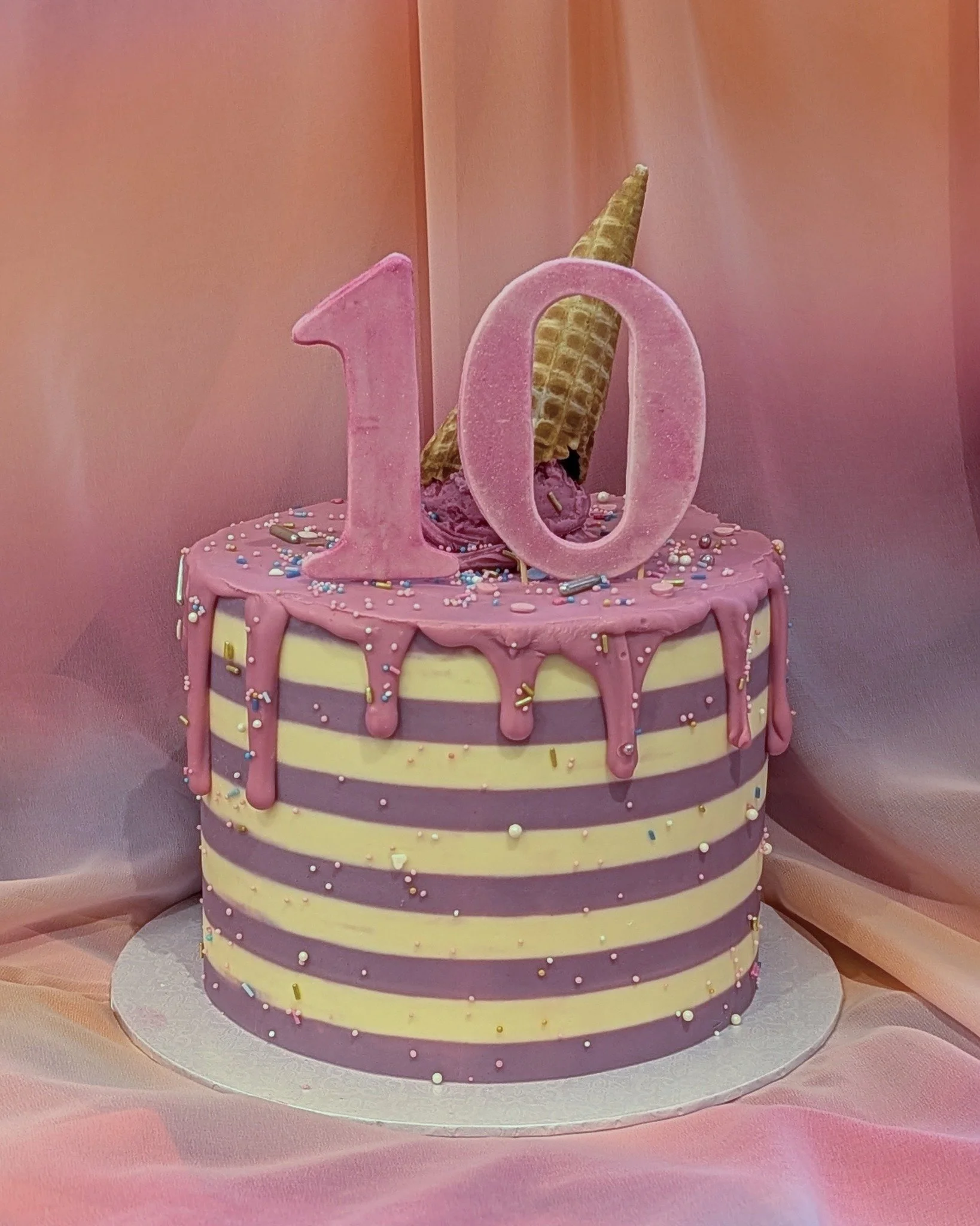 Chocolate cake with chocolate buttercream for a 10th birthday, finished with pastel stripes, a soft pink drip and an ice cream-style decoration on top.
This kind of design works really well for milestone birthdays - colourful and fun!

Custom birthda