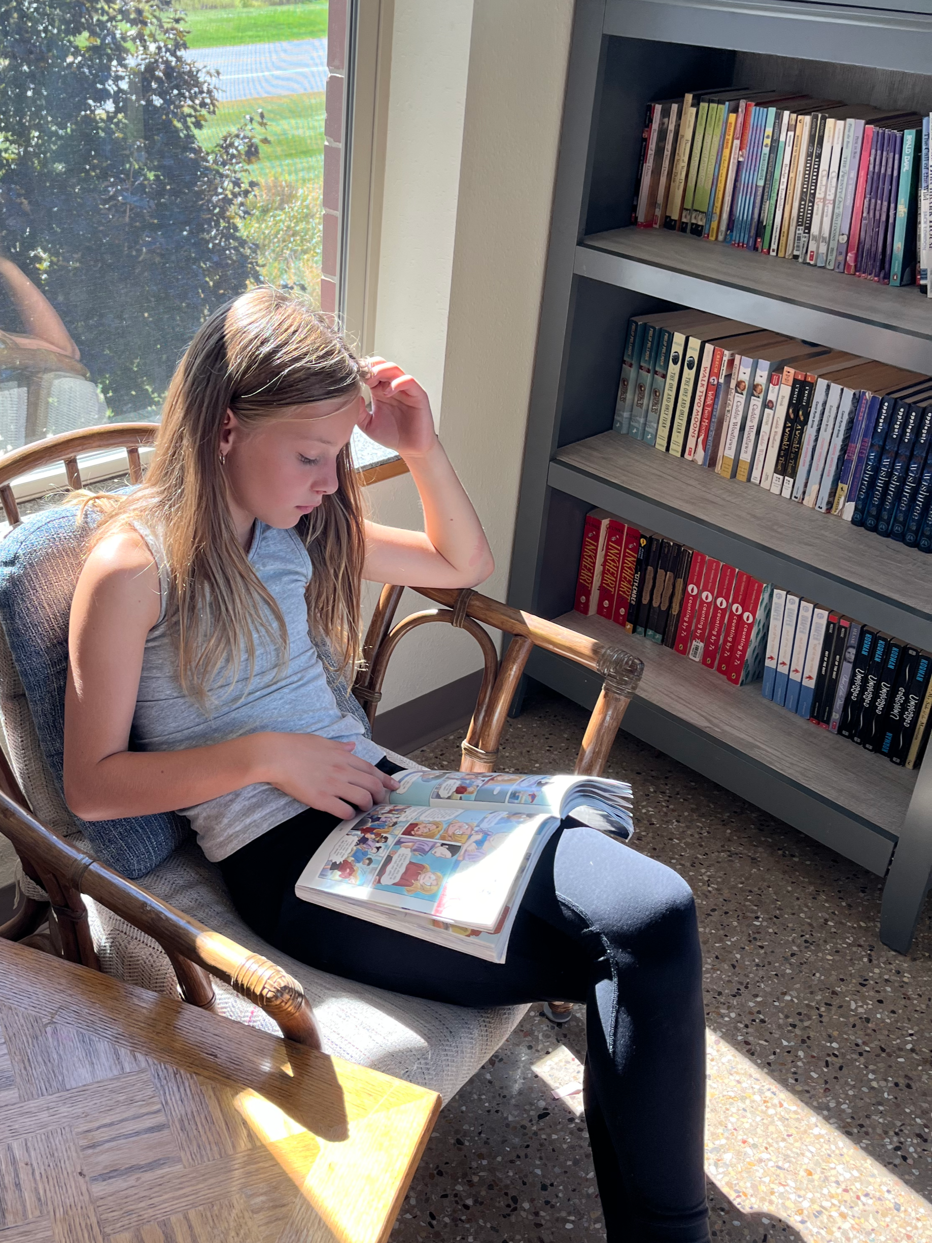 A girl reading quietly at Madison Community Montessori School