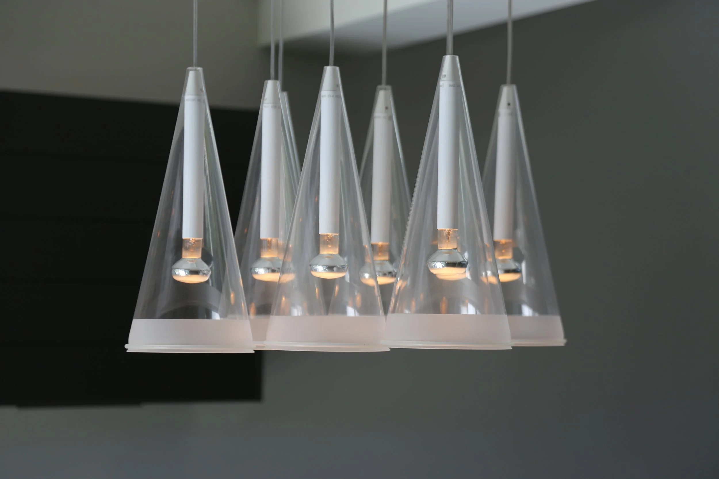 Modern conical pendant lights with a clear glass design.