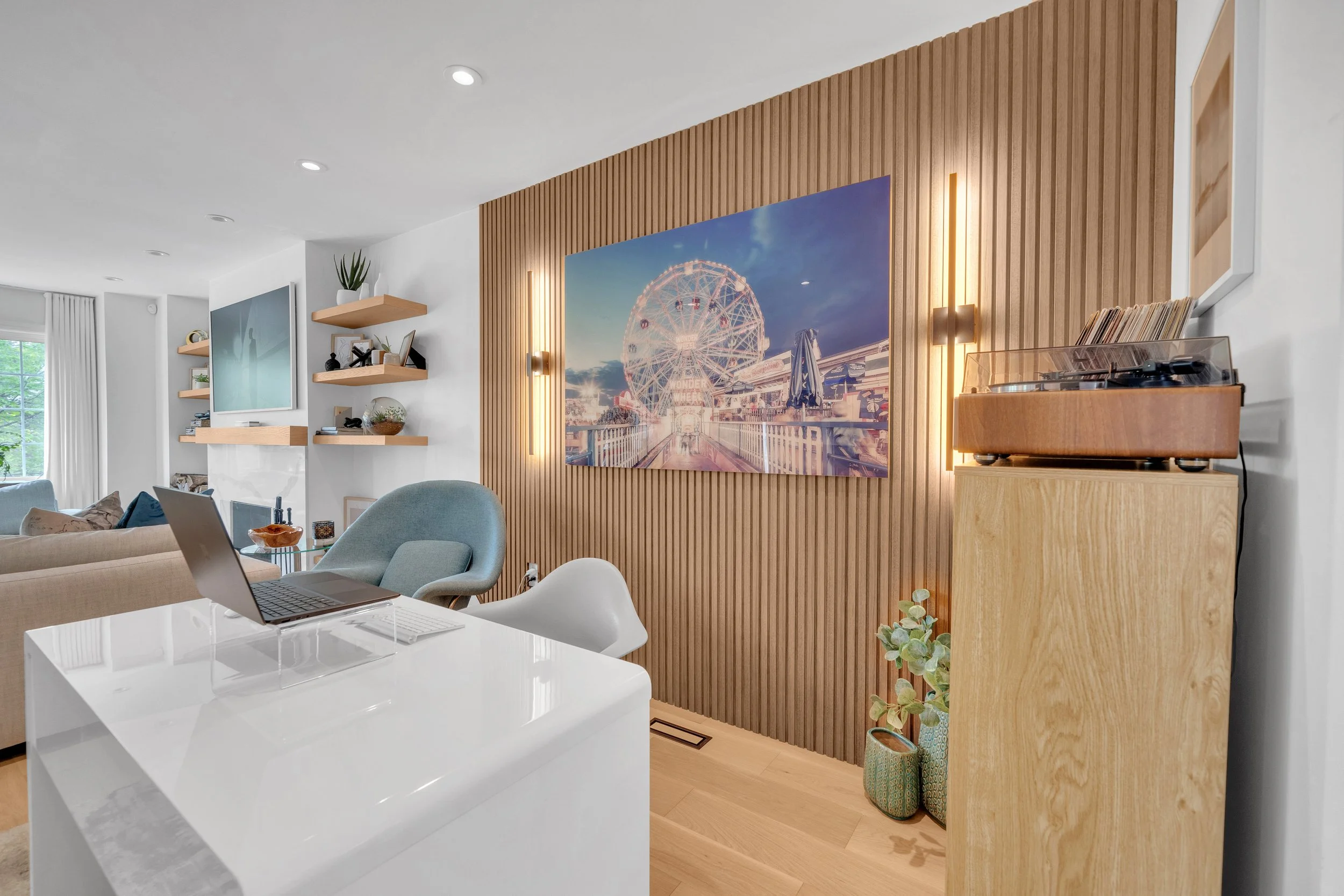 Modern living room with artwork, wooden paneling, and turntable