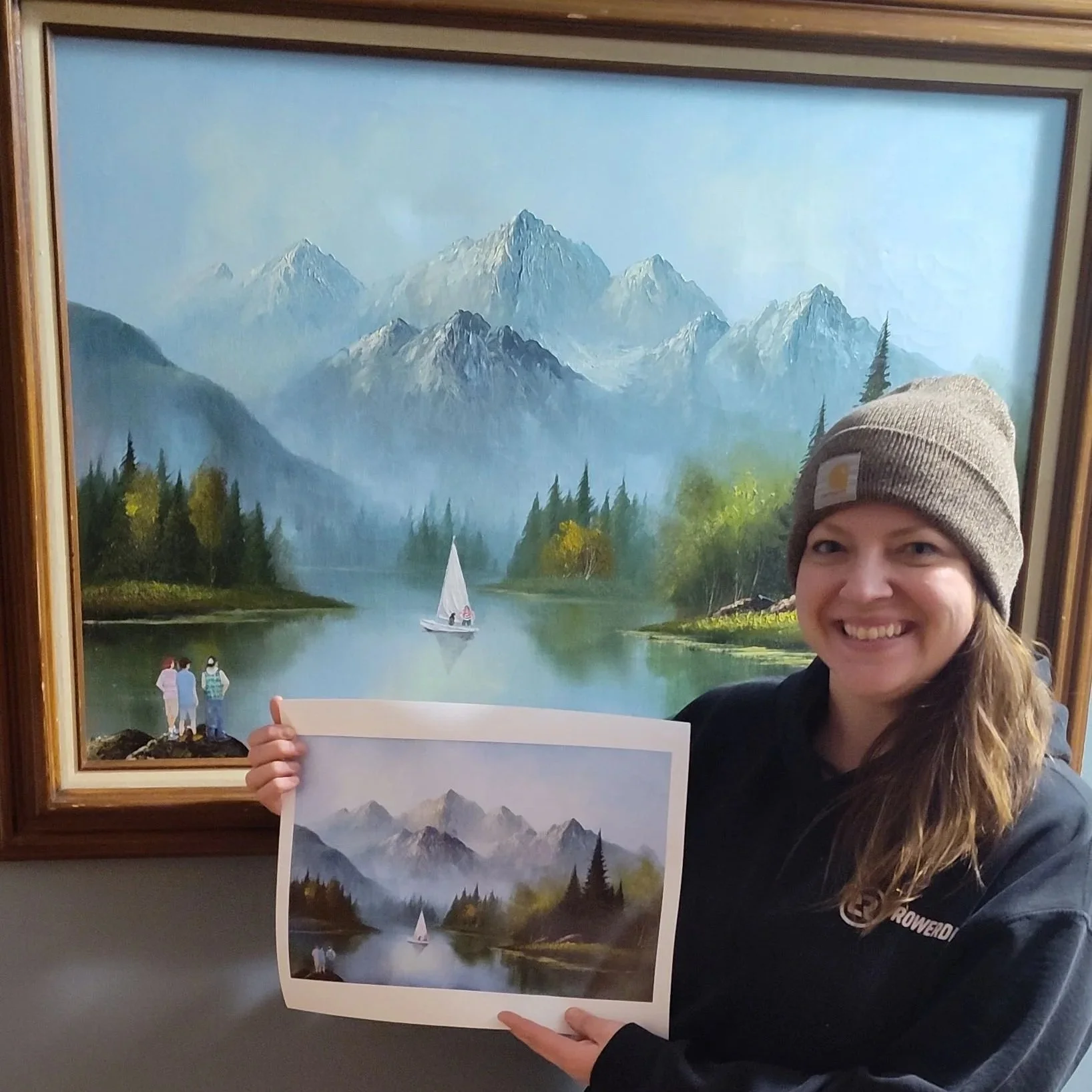 Artist holding print up to original.