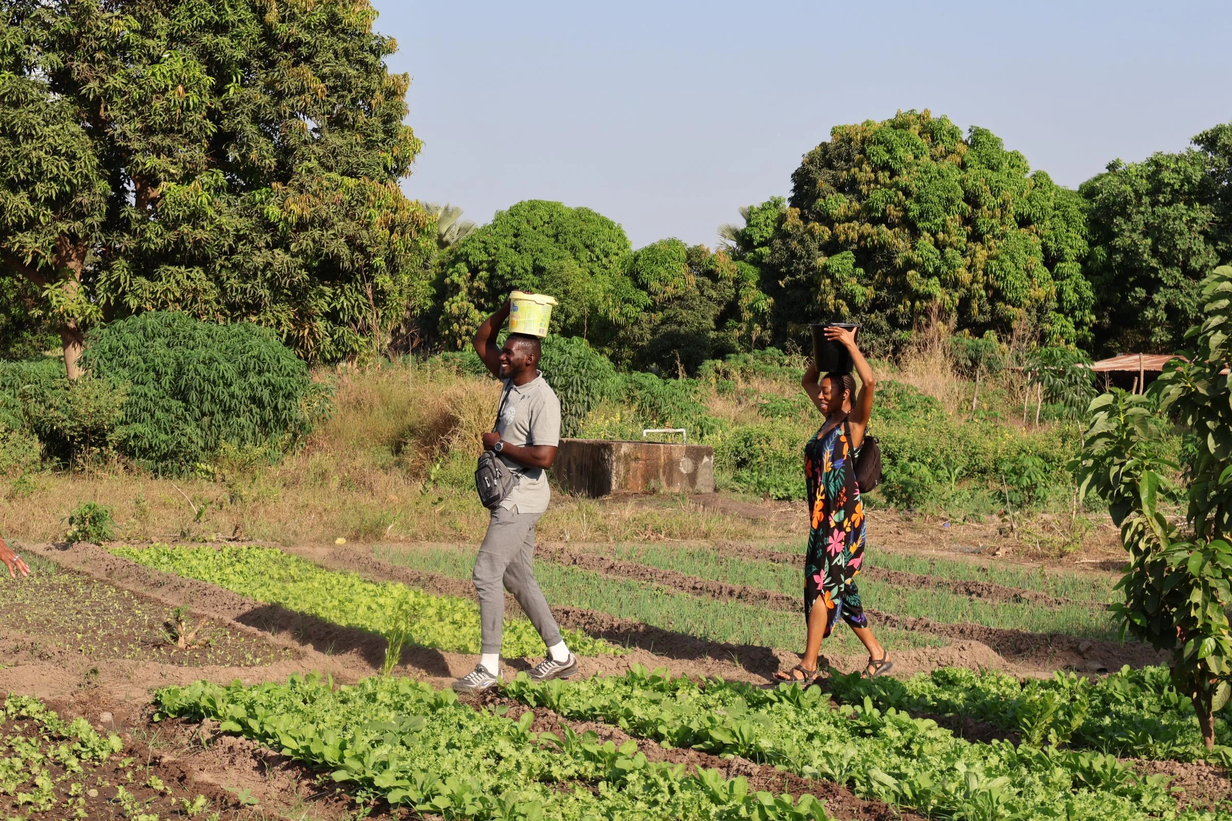 Nandi and tour member fetching water with the buckets on their heads.