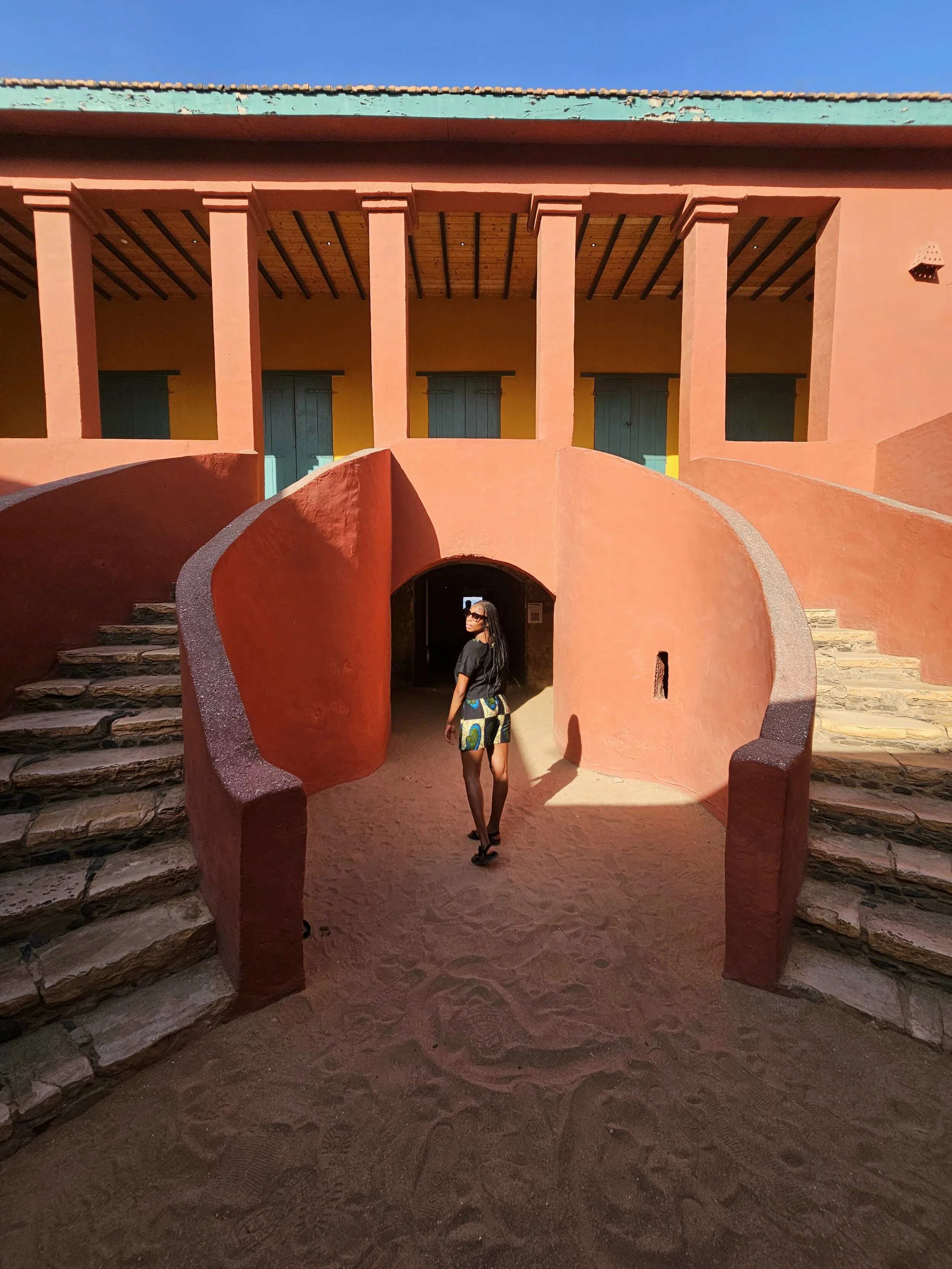 Nandi at Goree Island looking over her shoulder with the sun beaming brightly.