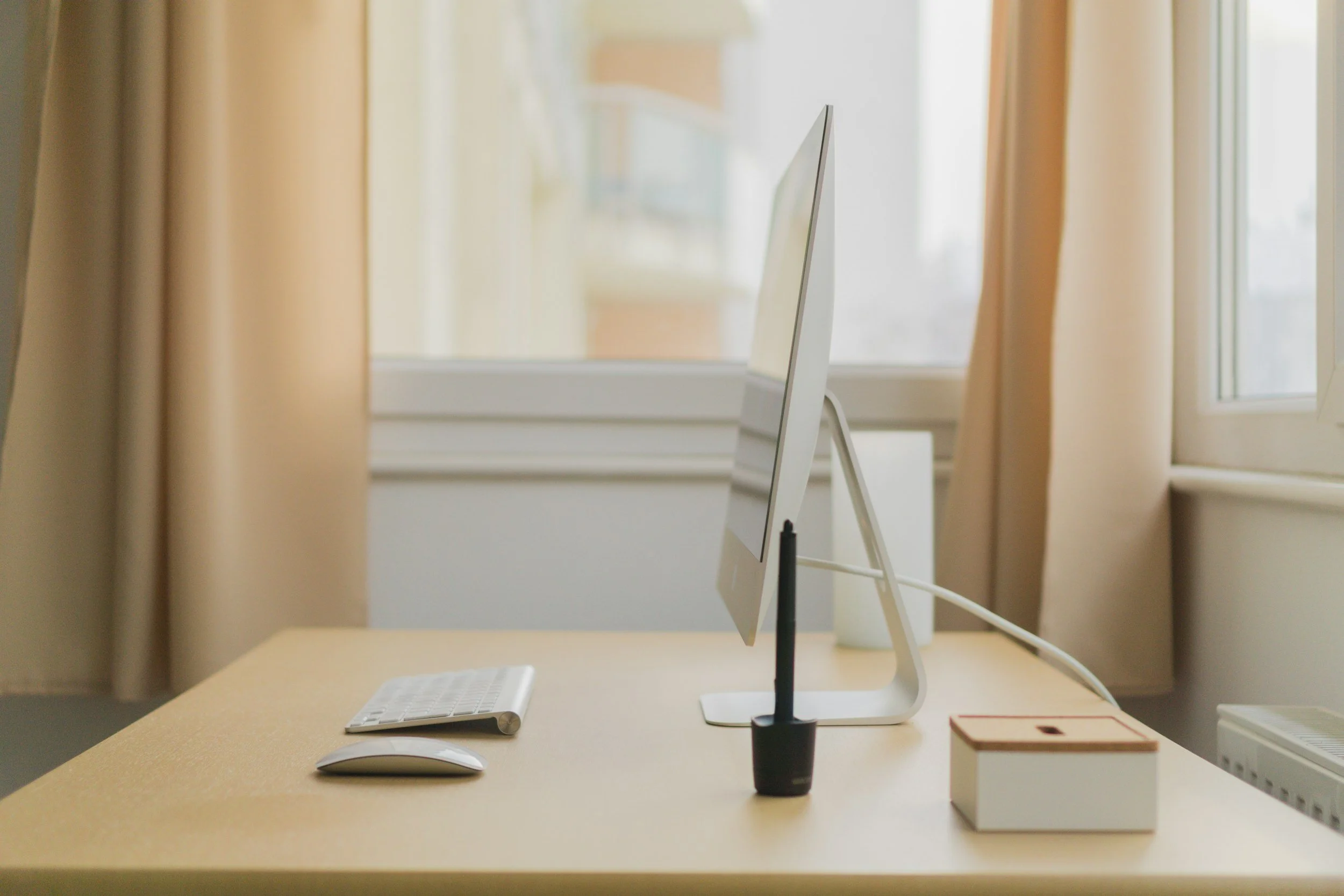 Side view of a simply set up desk with computer, keyboard and mouse.