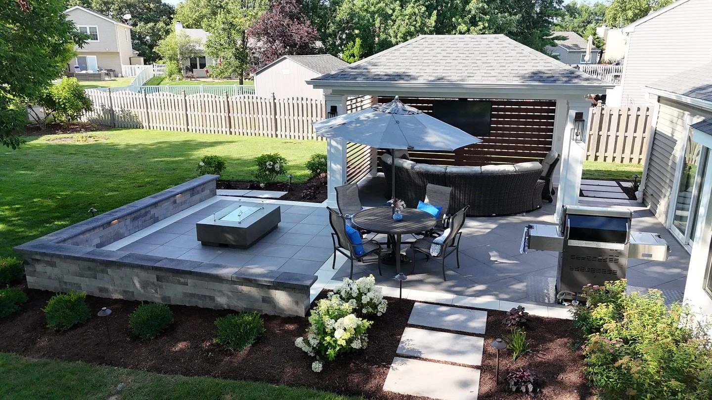 Transferred this backyard into a stunning outdoor oasis! 🌿🔥✨ Featuring a custom-built gazebo, cozy fire pit, intricate brick paver design, enchanting lighting, and lush landscaping — perfect for relaxing and entertaining all year round. #Back