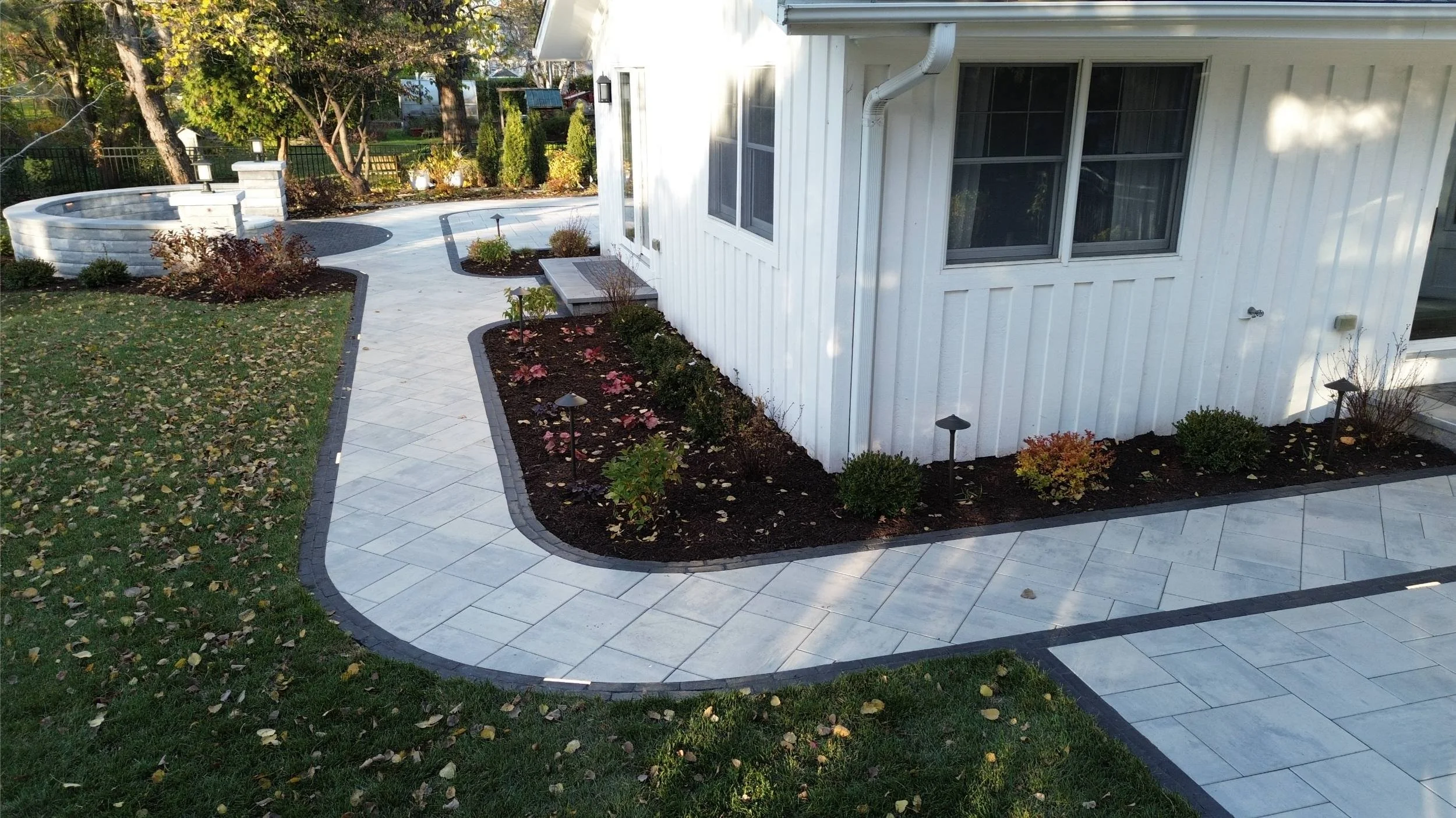 A welcoming outdoor space showcasing a paver walkway and stone retaining wall in Naperville, IL