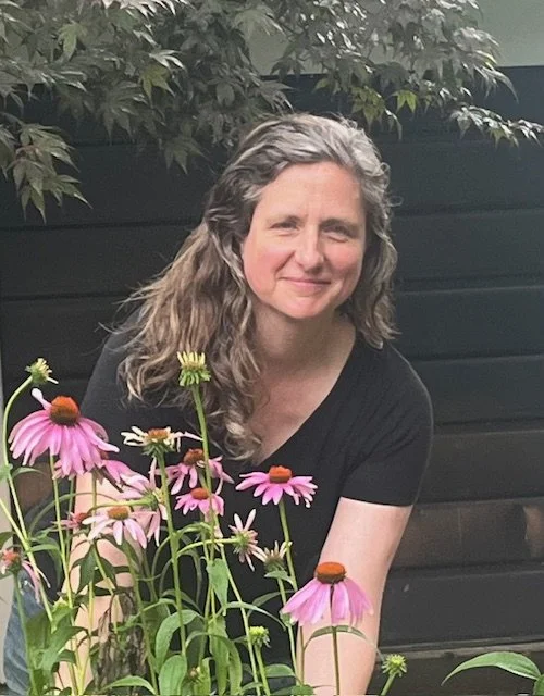 Smiling person outdoors wearing a green shirt