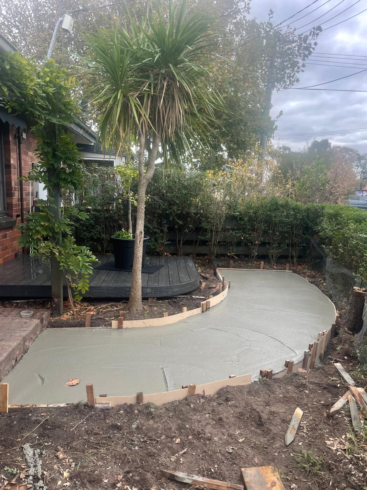 An in-progress photo highlighting the first steps of planting and hardscaping in the garden redesign, adding structure and form to the outdoor space.