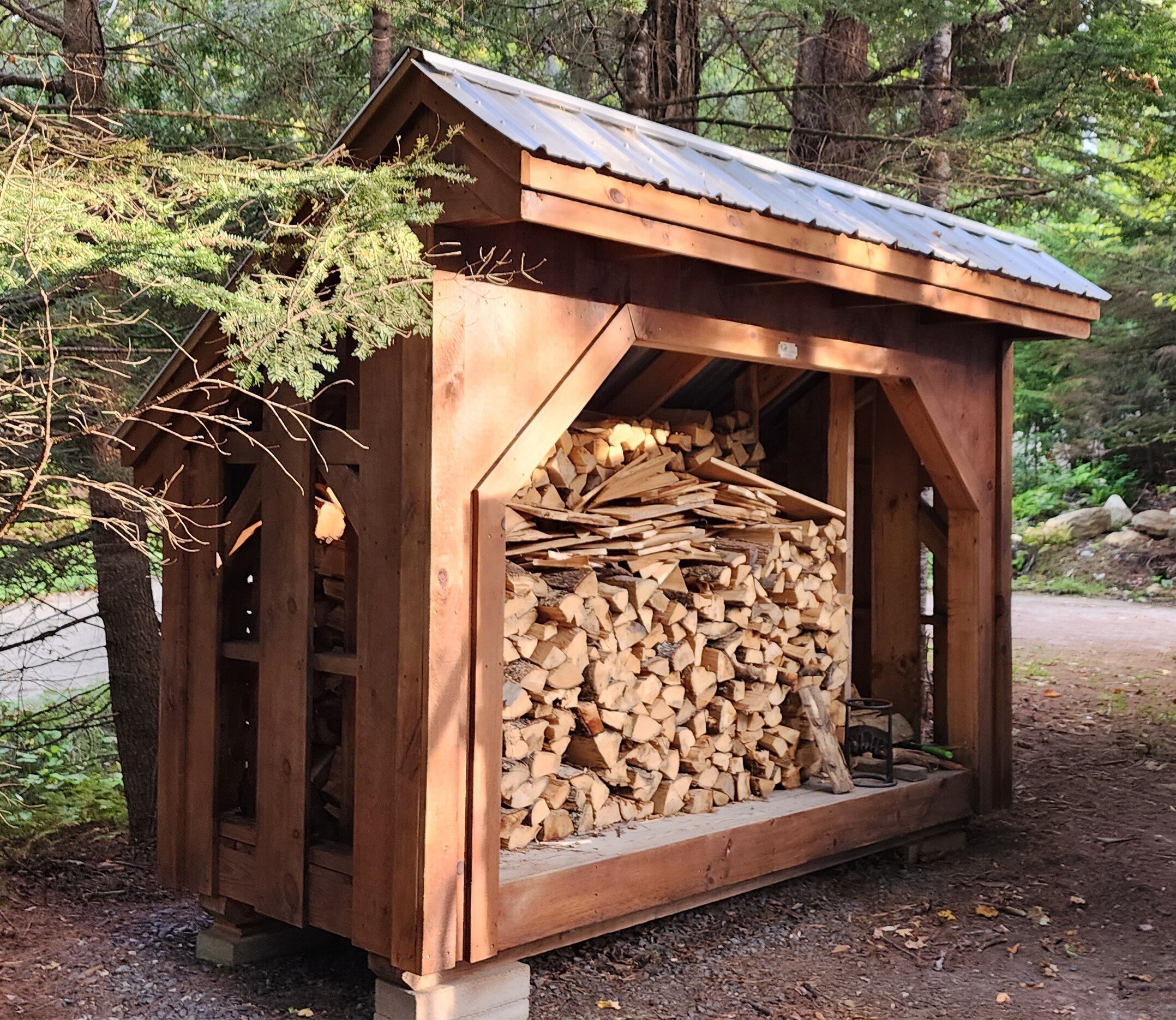 We cleaned and stained three outbuildings to match, as well, including a sleeping cabin, a utility shed, and this firewood shelter.