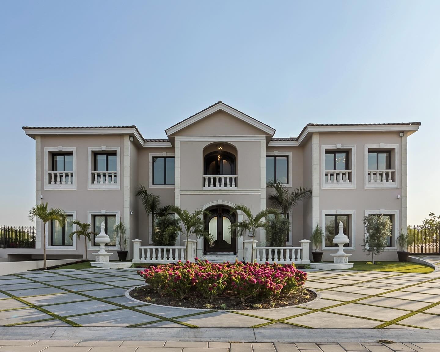 Villa Eleganza is a striking contemporary neoclassical residence distinguished by its symmetrical cantera stone fa&ccedil;ade, refined moldings, and hand-carved columns. A grand foyer opens to a double-height living and dining area with elegant chand