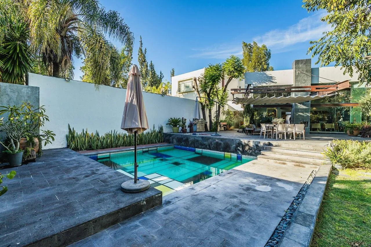 Casa Atelier blends contemporary design with artistic character, defined by materials like Galala marble, oxidized steel, polished concrete, and bamboo. A skylit hallway leads into a double-height living and dining area, where large windows open dire