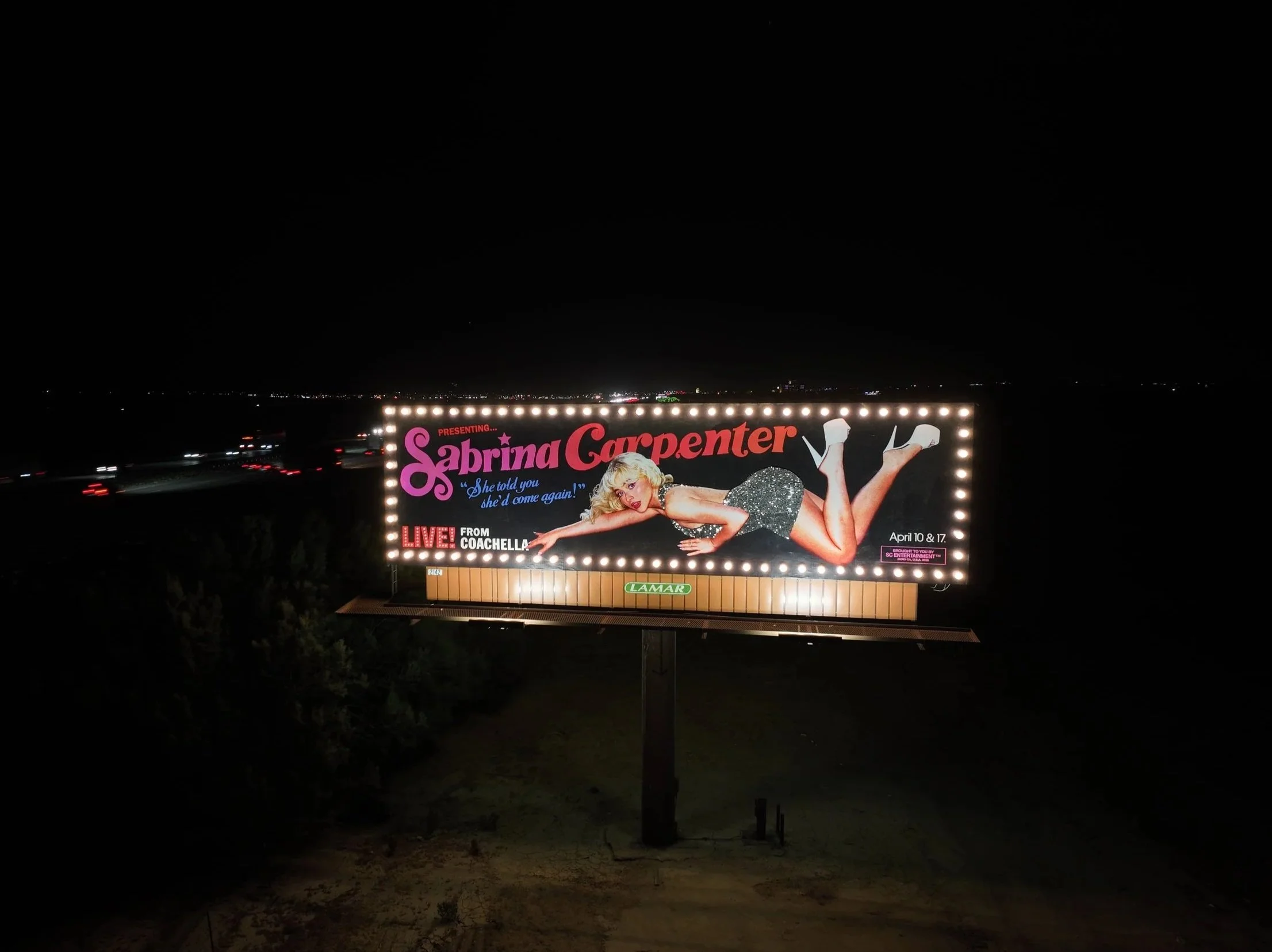 Billboard advertising Sabrina Carpenter's upcoming live shows in Coachella, featuring an image of Sabrina Carpenter lying down in a sparkly dress and high heels, at night on the highway.