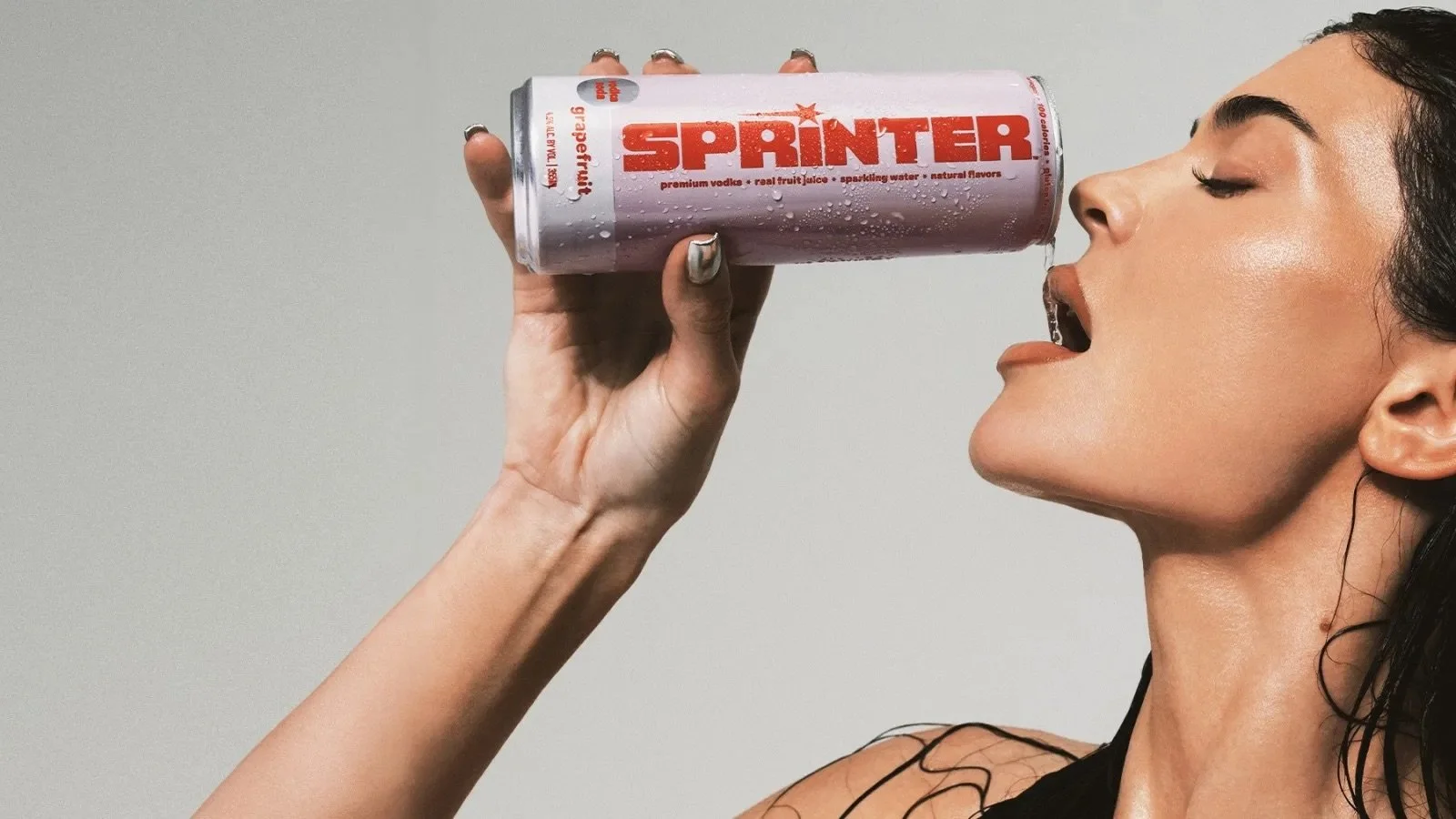 Kylie Jenner  drinking from a can labeled 'SPRINTER' with water dripping from her mouth.