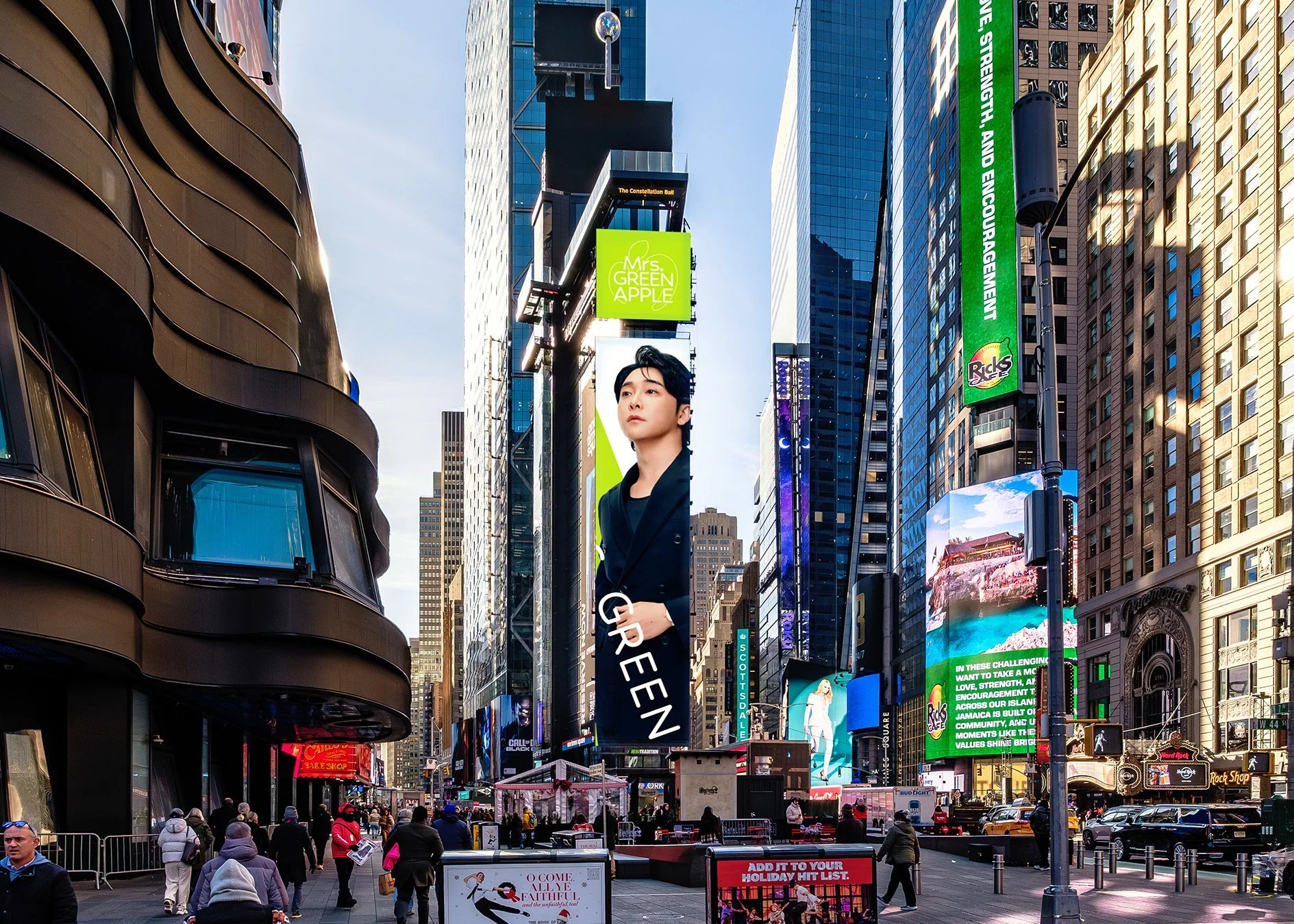 View of Times Square in New York City with a digital billboard featuring Mrs. Green Apple. People walking, and tall buildings.