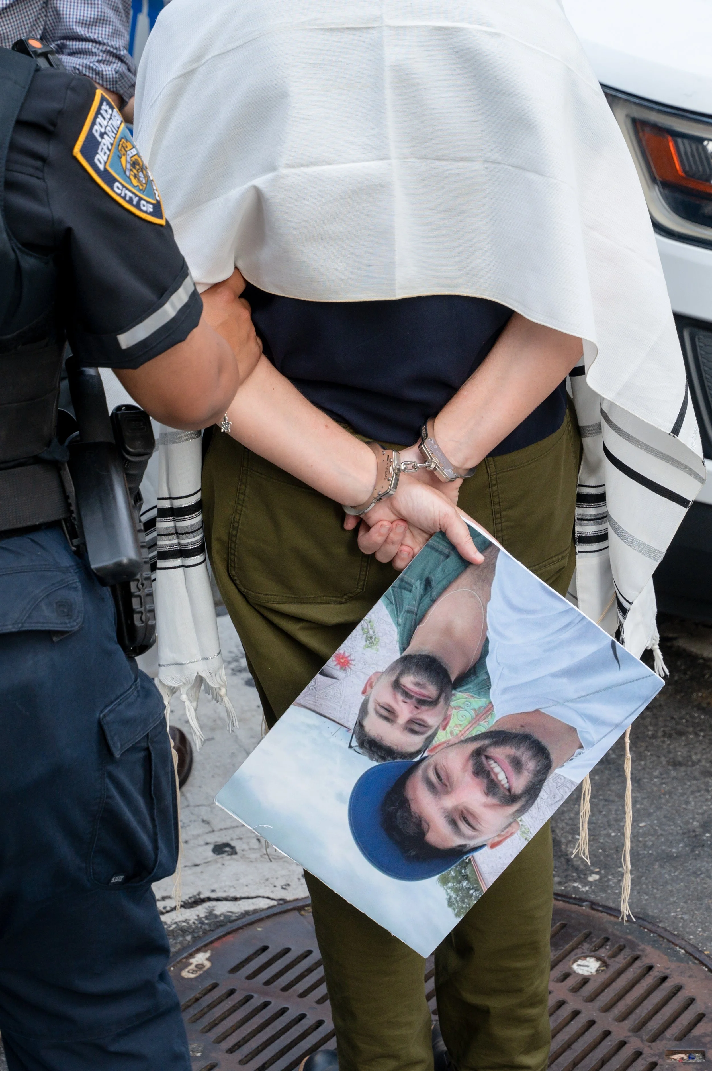 NEW YORK, NY – JULY 28: A protester is arrested while holding photos of hostages during a demonstration outside the Israeli Consulate in New York, where Israeli and Jewish groups called to end the war in Gaza and return the hostages, in New York City