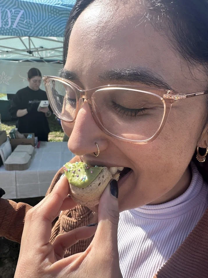 Person eating donut from Seedz Cafe at STL Vegan Market.jpg