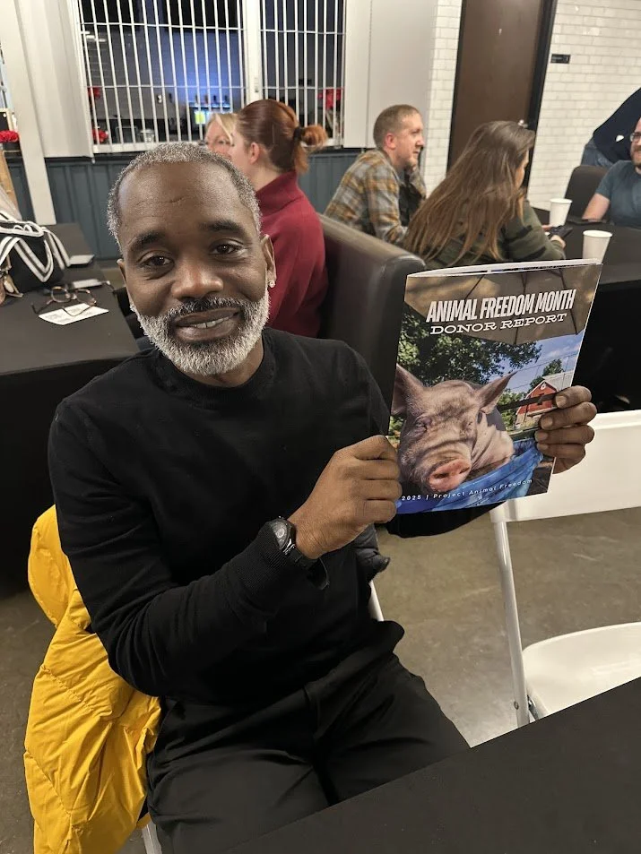 Guest holding an Animal Freedom Month Donor Report from Project Animal Freedom at our Vegan Thanksgiving Feast at Adina's Vegan Cuisine in St. Louis, Missouri.jpg
