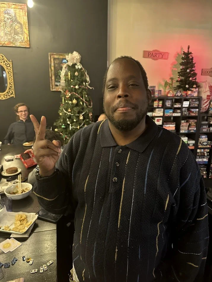 Jw making a peace sign while smiling into the camera at our Vegan Game Night and St. Louis Veganuary campaign meeting.jpg