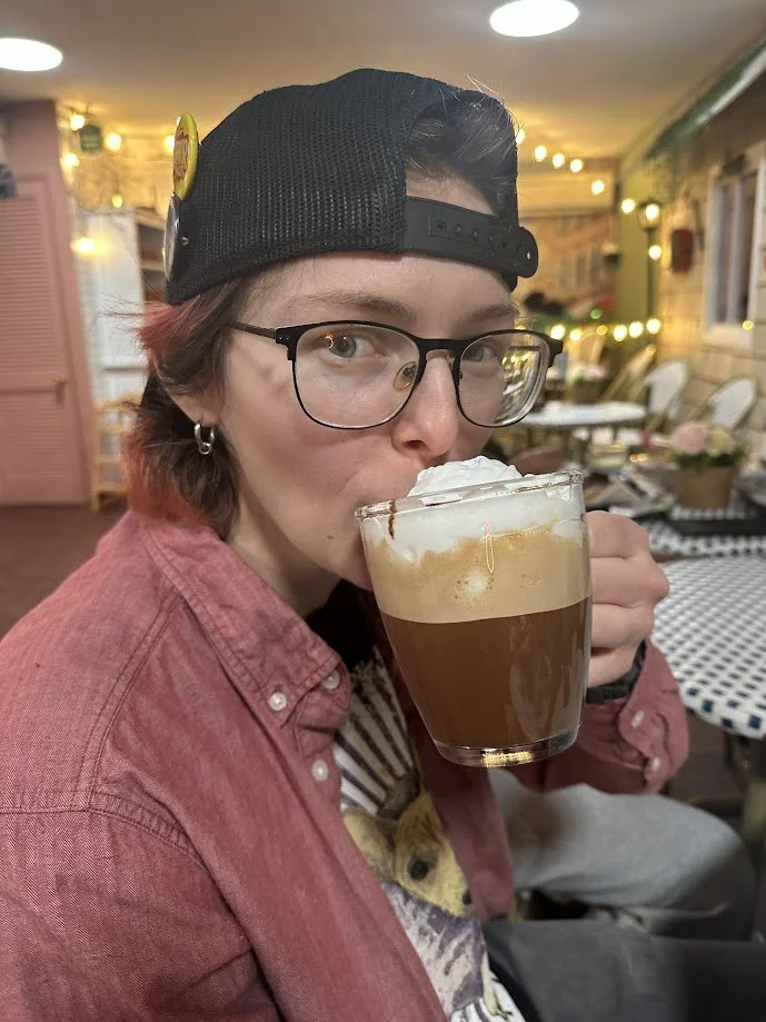 Jaimie drinking a coffee with foam at La Vie Vegan Bistro in St. Charles, Missouri.jpg