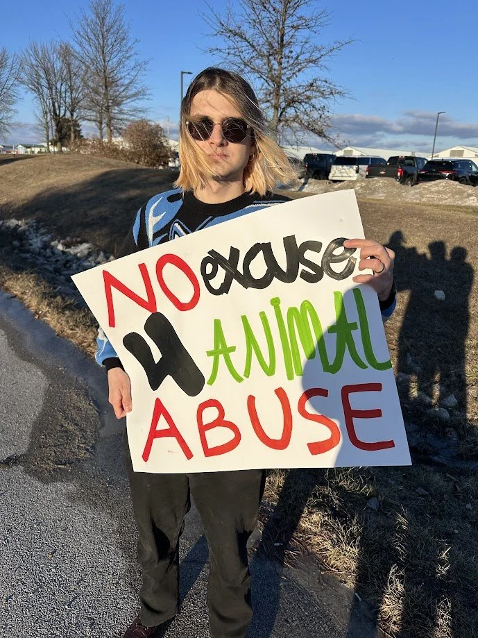 Vanya holding a sign saying there is no excuse for animal abuse.jpg